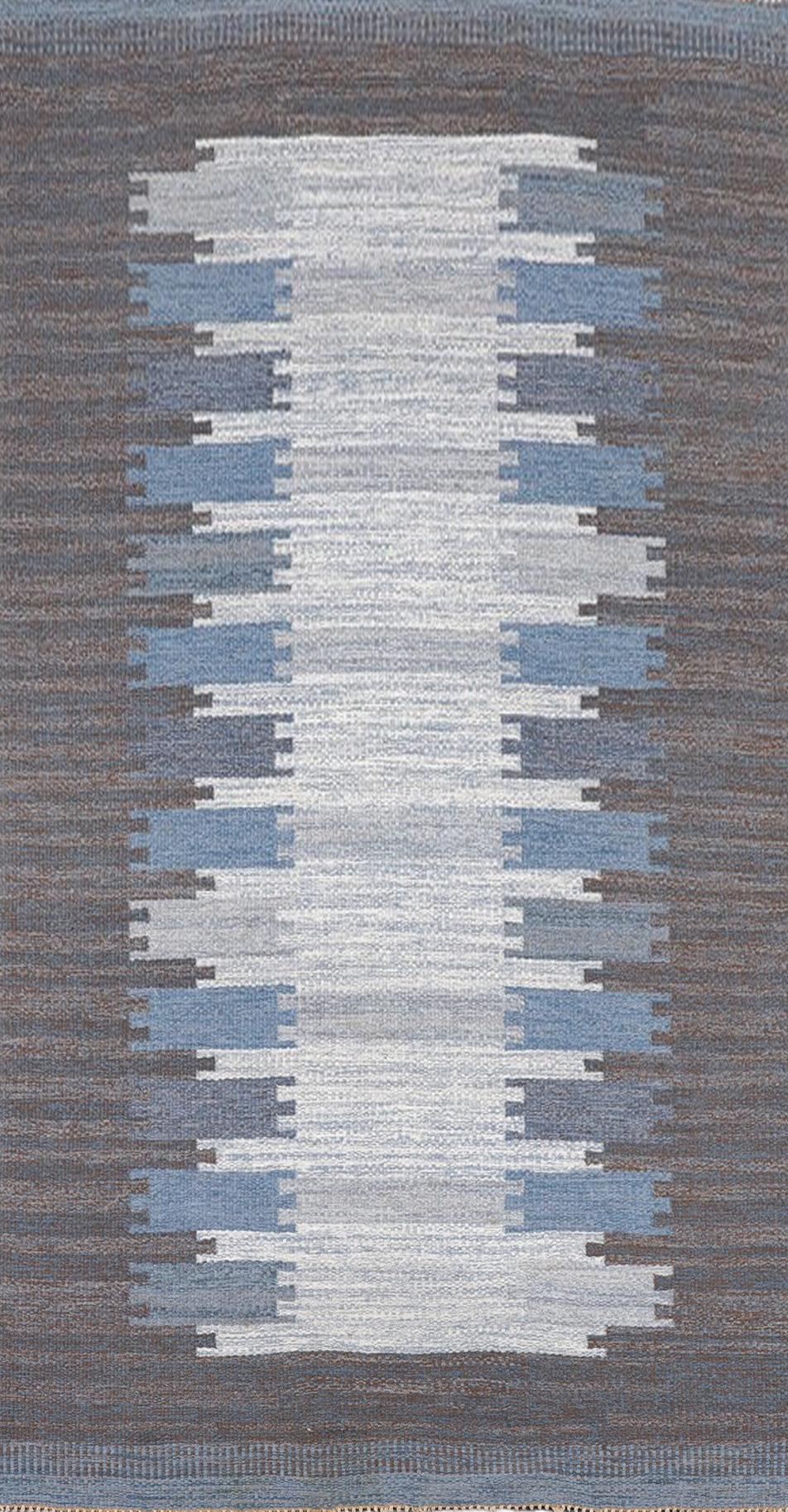 This vintage Swedish rug, hand woven wool, flatweave ‘rolläkan’ was designed by Margareta Lundahl, master weaver in the Mid-20th Century in Sweden. This rug dates to around 1950s. Geometric pattern in (light) grey and blue, 250 x 151 cm. Signed