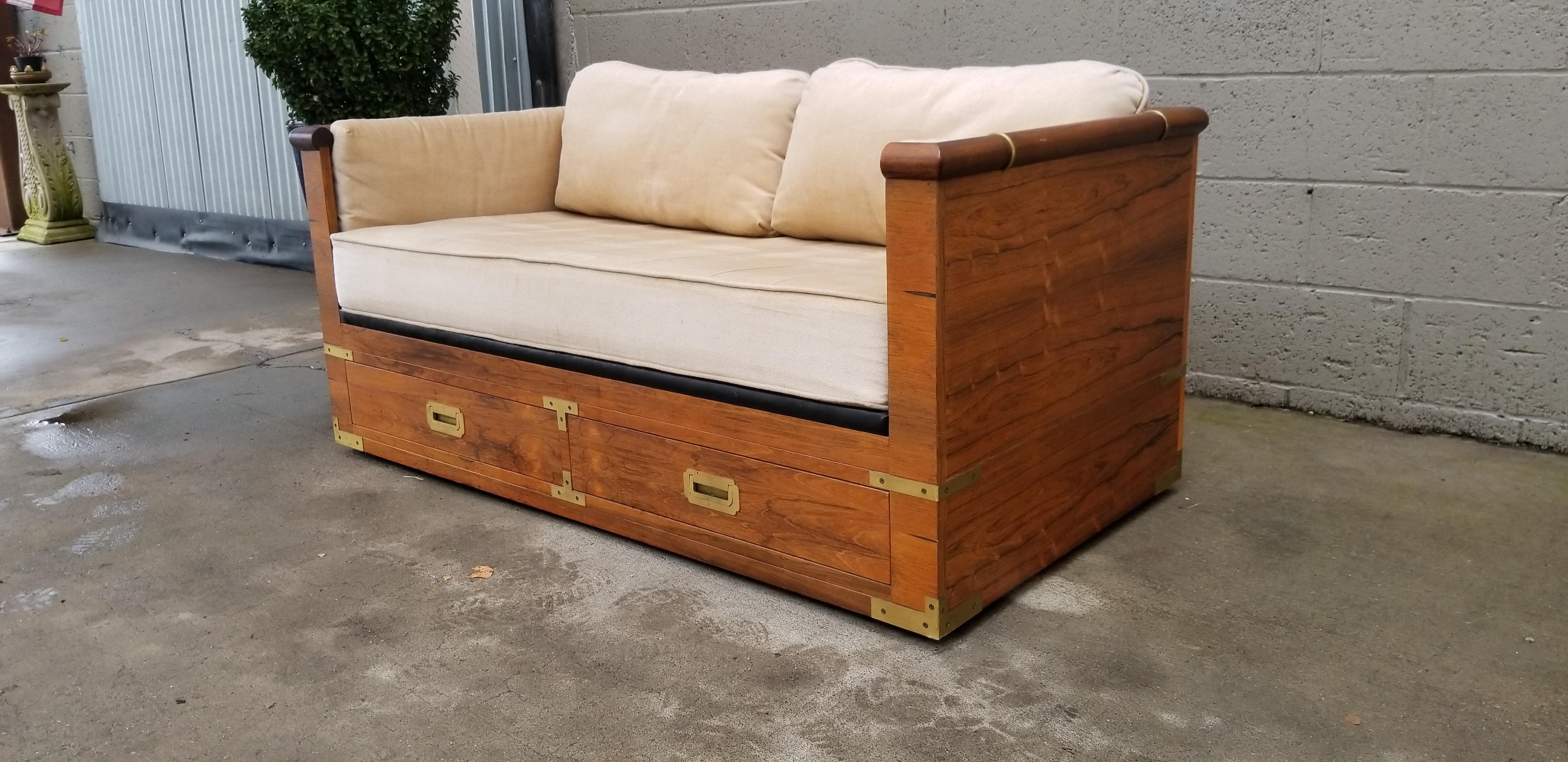 Fine craftsmanship and materials throughout in this rosewood loveseat by Marge Carson, circa 1970s. Finished on all sides with a beautiful figured rosewood and brass detail. Two drawers for additional storage. Goose down filled cushions. Rosewood