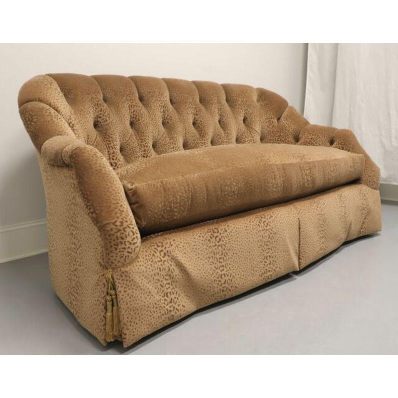 A Transitional style loveseat by high-end furniture maker Marge Carson, of Pomona, California, USA. Wood frame construction, upholstered in a soft velvety brown color textured leopard print fabric with skirt, button tufted and down filled bottom