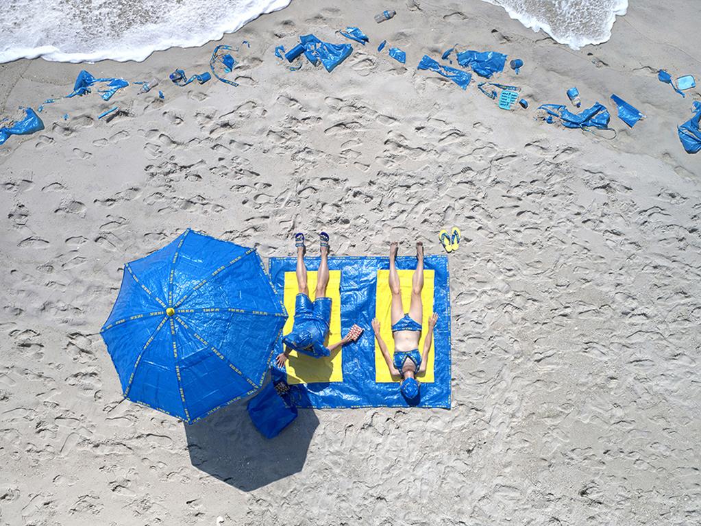 Margeaux Walter Landscape Photograph - Some Assembly Required - Ikea blue bag fashion, sandy beach summer sunbathing
