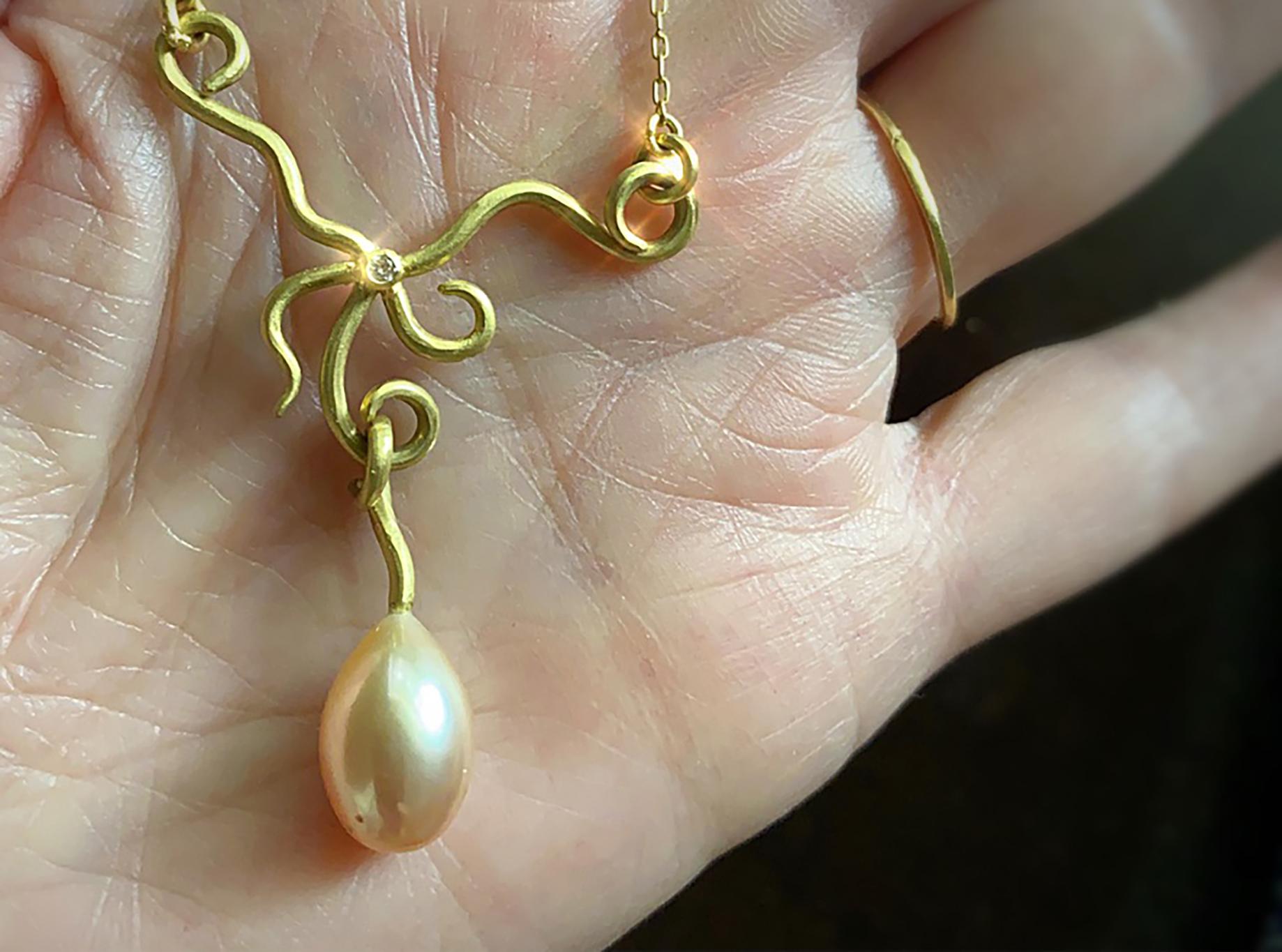 A one of a kind lavalier completely handcrafted in 18k gold featuring a beautifully hued pearl drop and a 2 mm brilliant cut diamond.  The lavalier is attached to a 17.5