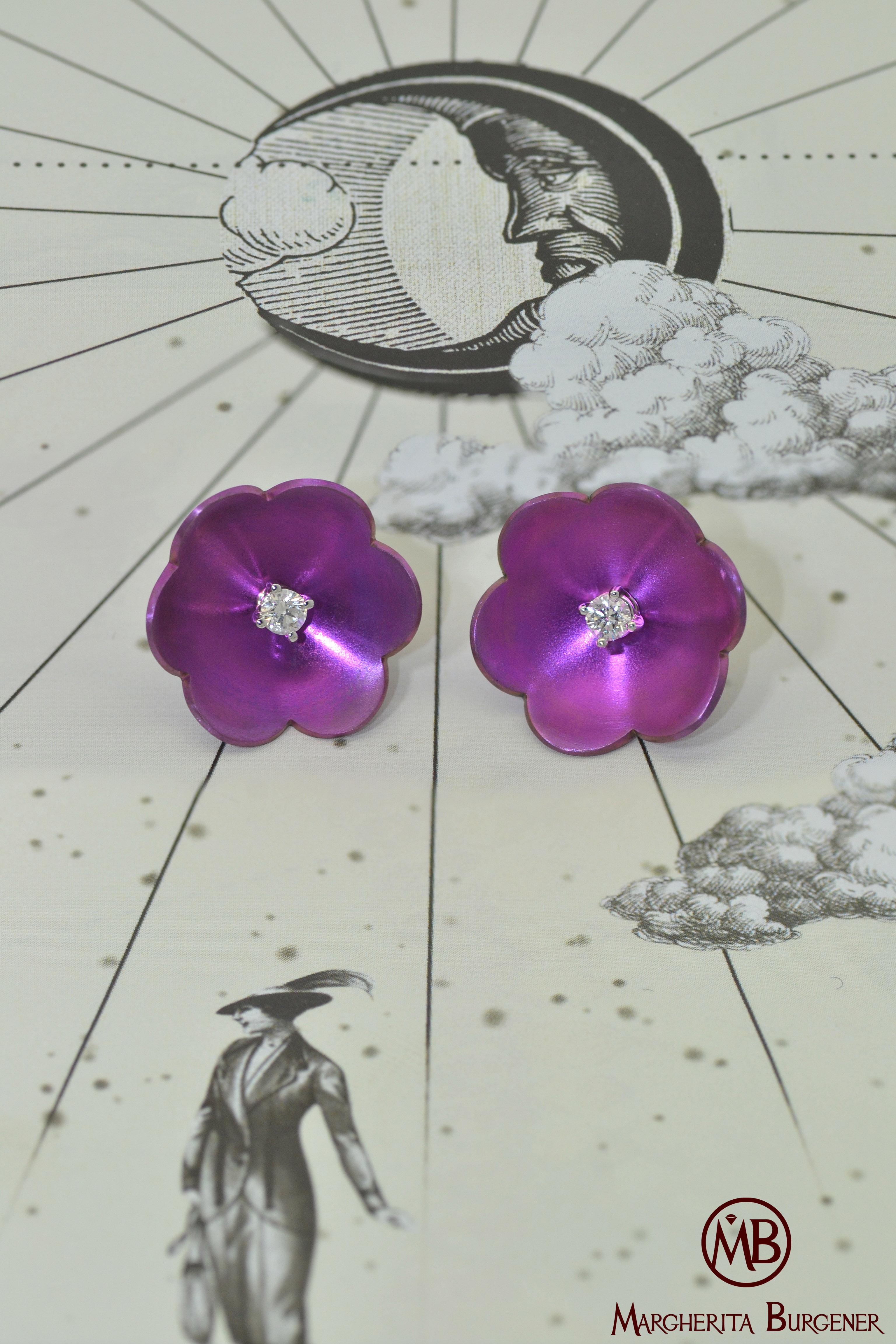 Handgefertigt in der Familienfabrik von Margherita Burgener,  die Transformator-Ohrringe mit Blumenmotiv sind mit einem einzelnen Diamanten in 18 KT Weißgold gefasst. 
Diamanten können aus der Blüte entnommen werden  und als einzelne Stollen