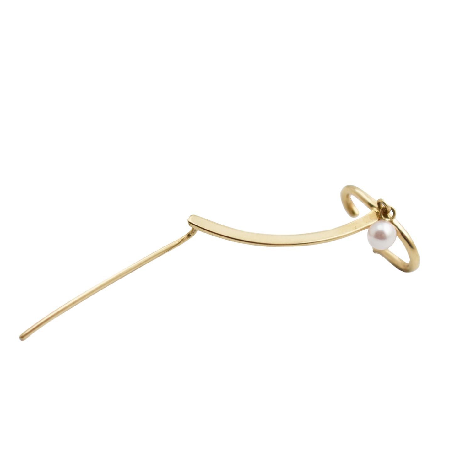 The Margie Pearl Cuff Needle Gold Earring is a statement earring in solid 14k gold featuring a pearl dangle. Its subtle design follows the outline of the ear finishing in a comfortable cuff. 

How to wear it: 

Thread the needle end of the earring