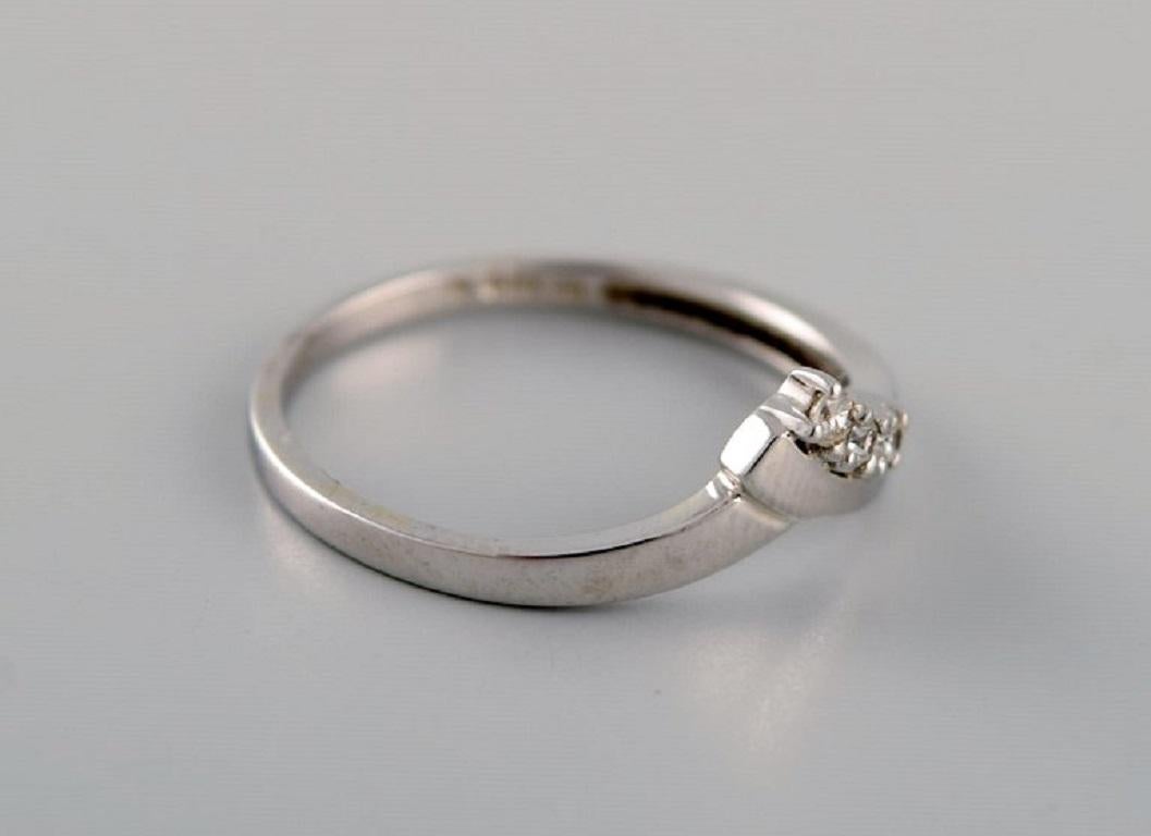 Collezione Margit E., Danimarca. Anello Alliance in oro bianco 9 carati con zirconi. 21° secolo.
Diametro: 17,75 mm.
Misura USA: 7.5.
In ottime condizioni.
Timbrato.
Nella maggior parte dei casi, possiamo cambiare la misura pagando una tassa (USD