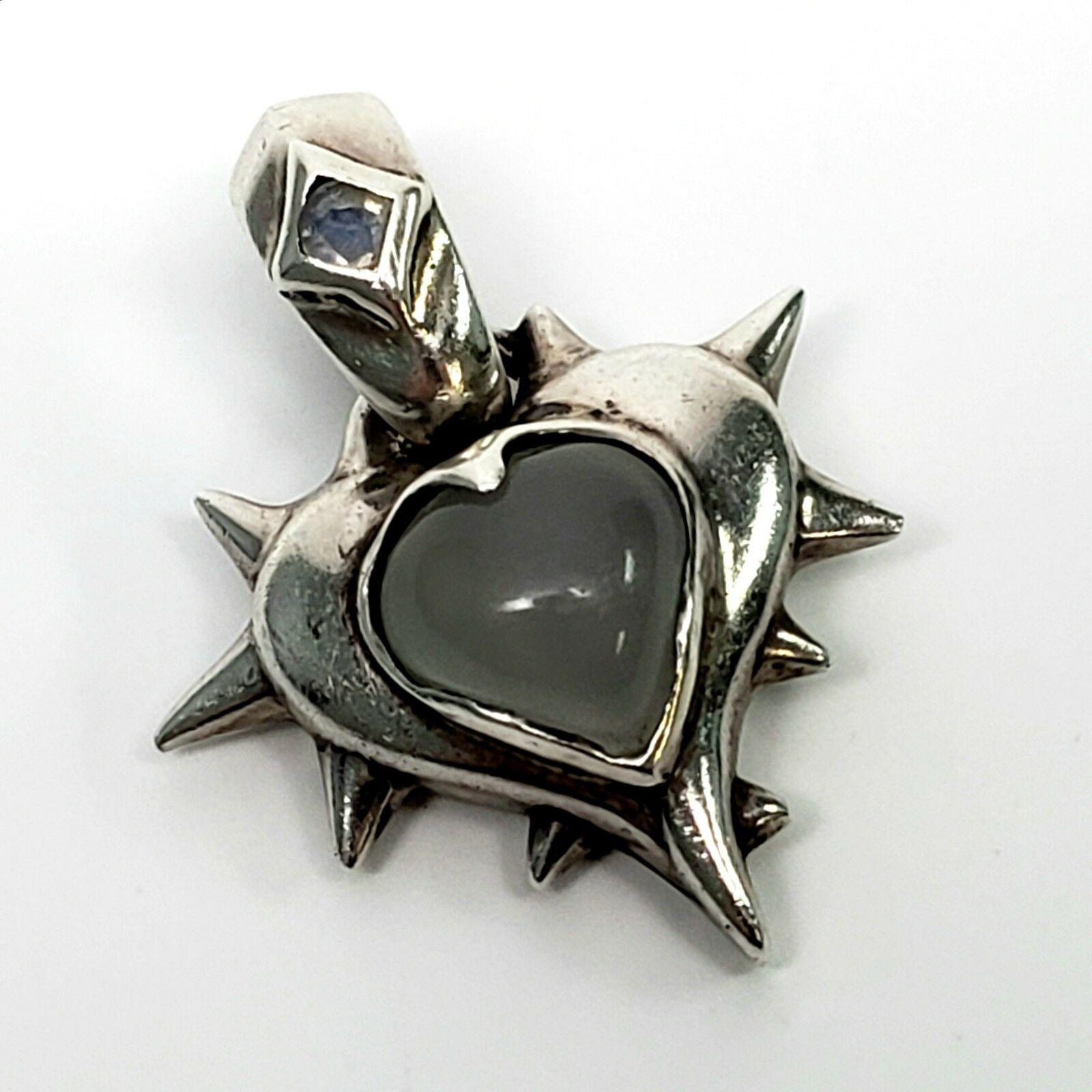 Margo Manhattan Sterling Silver Moonstone Rocket Heart pendant.

Features a small moonstone on bail, and a larger moonstone cabochon at the pendant's center. By Manhattan based designer, Margo. Bail opens with a hinge and a figure 8