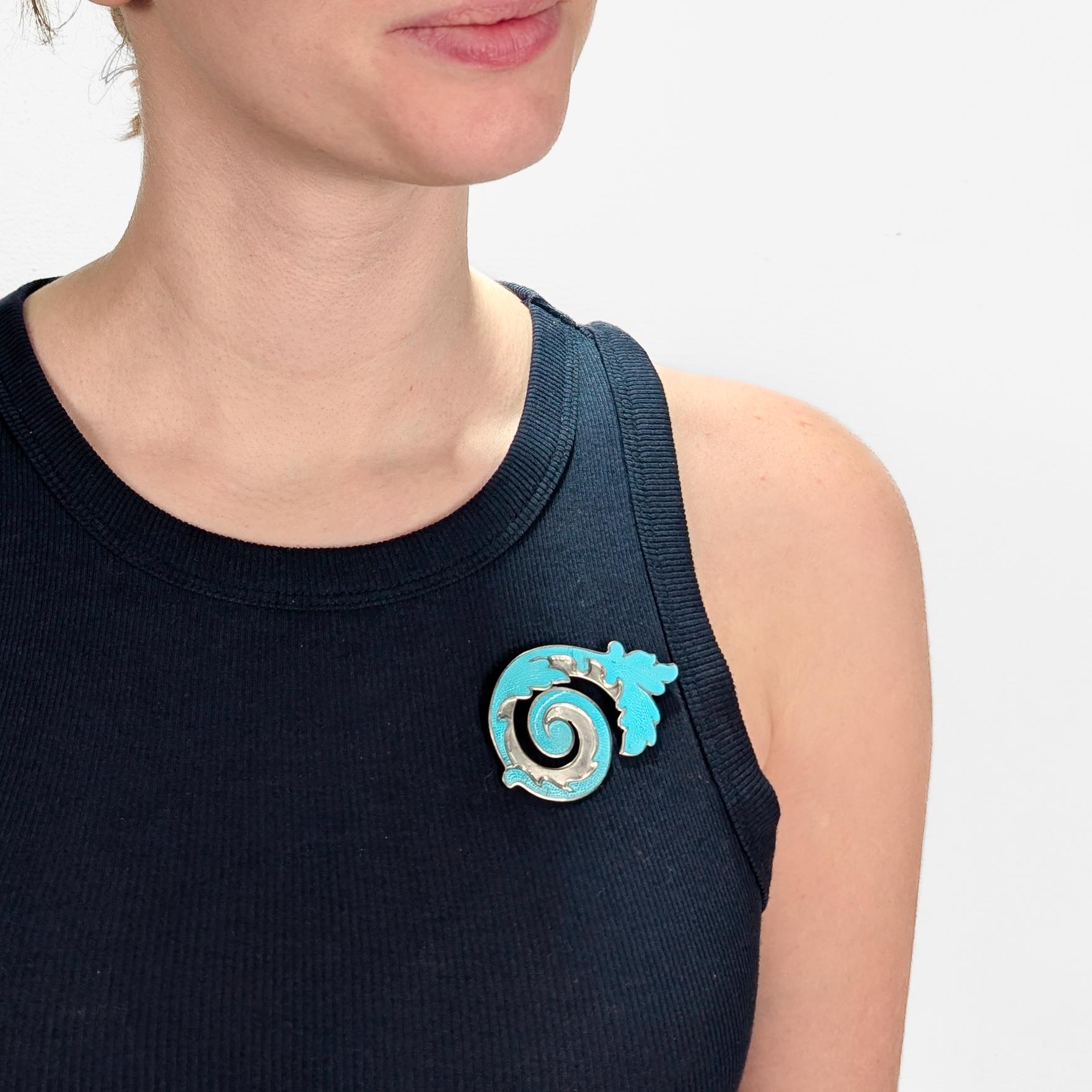Broche en argent et en émail signée du Mexique.

Par Margot de Taxco.

En argent sterling avec émail bleu turquoise.

Sous la forme d'une feuille ou d'un brin enroulé.

Entièrement marqué au verso.

Tout simplement une magnifique broche moderniste