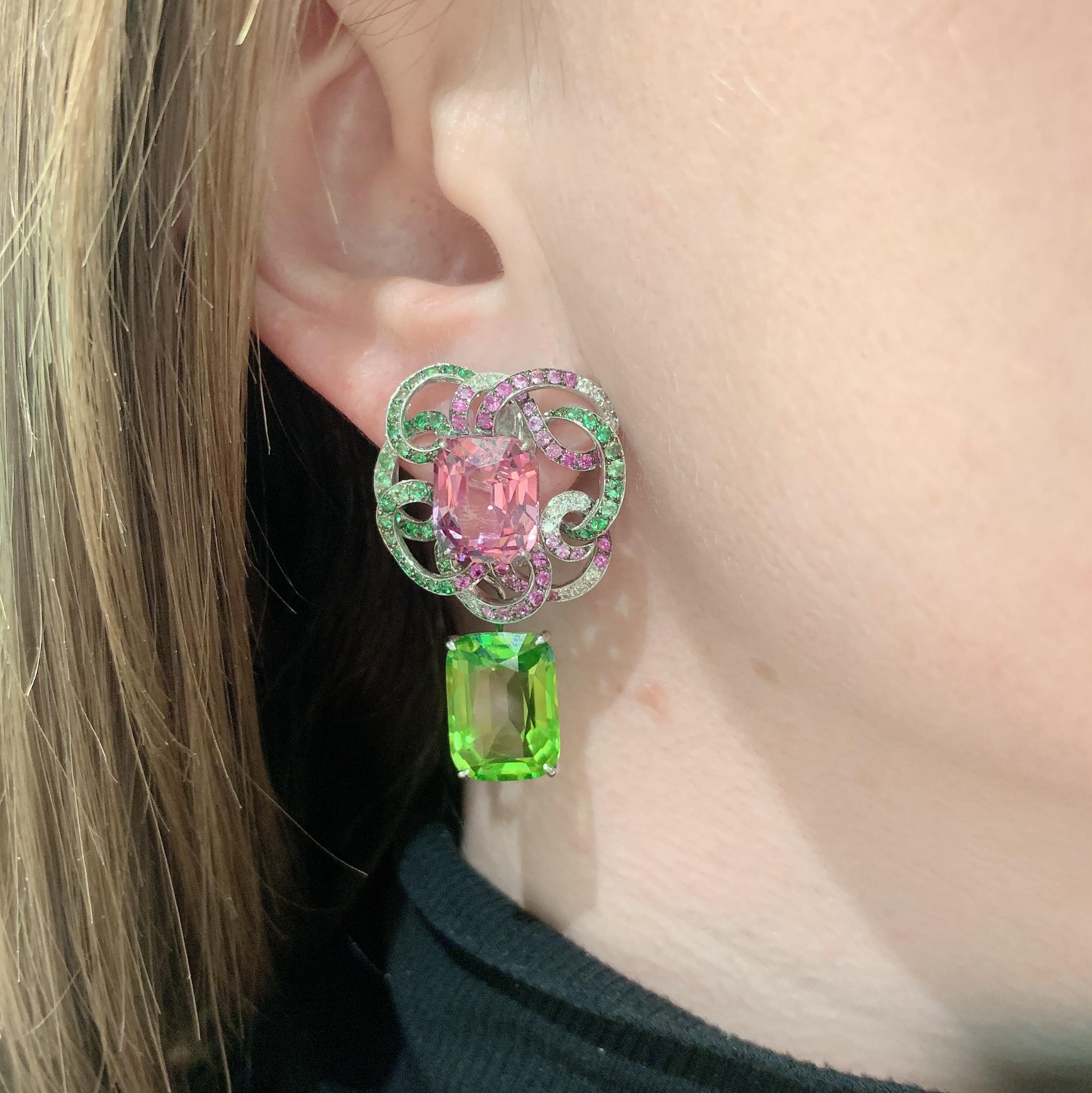 Margot McKinney 18 karat White Gold Earrings set with a pair of Pink Spinel 14.19ct surrounded by a swirl of  35 White Diamonds 0.47ct, 99 Tsavorite Garnets 1.41ct and 80 Pink Sapphires 1.08ct with a pair of detachable Peridot 15.77ct Pendant Drops.
