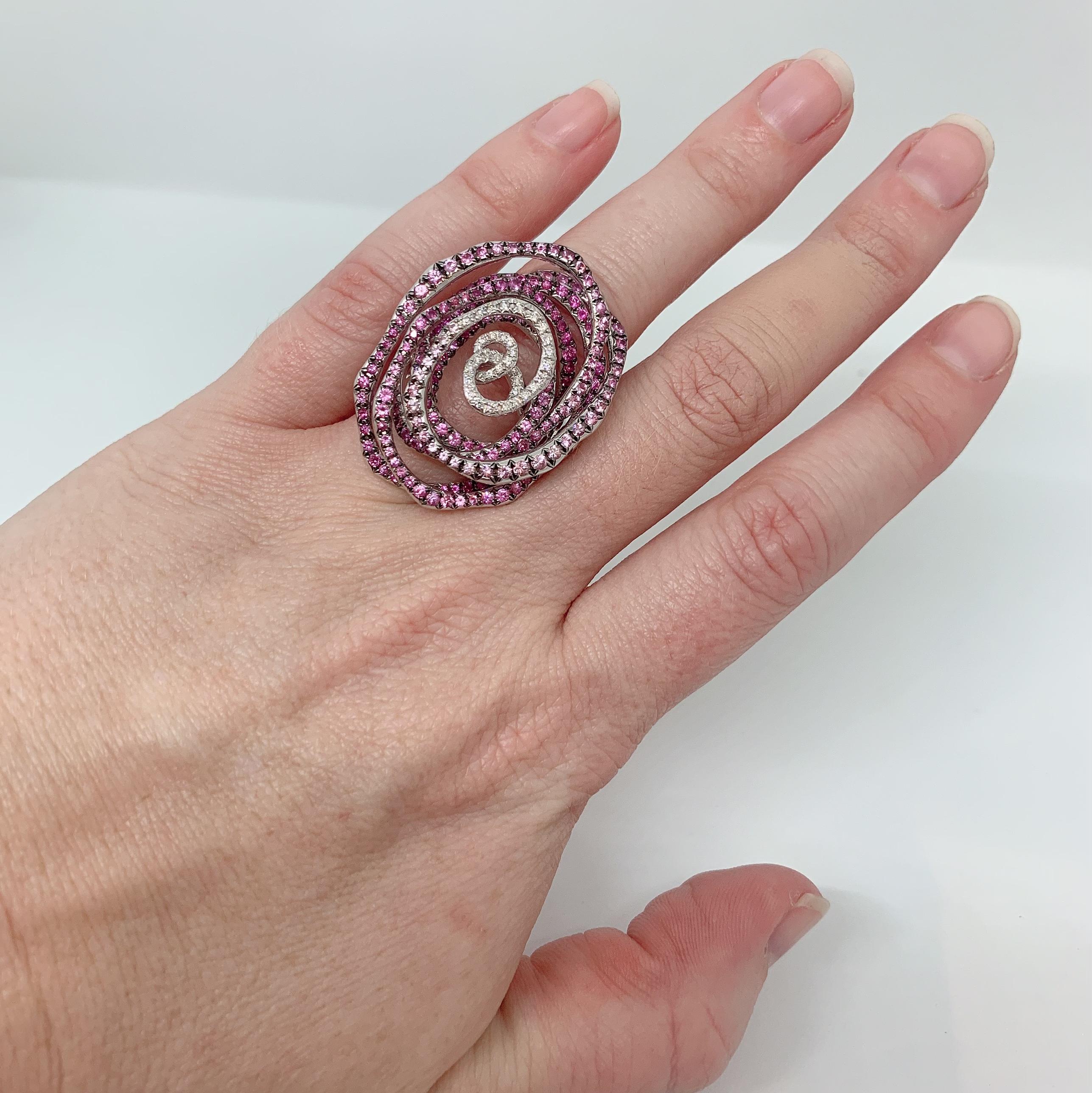 Margot McKinney 18 Karat White Gold Swirl Ring set with 0.27 carat White Diamonds and 3.14 carat Pink Sapphires.  Ring Size USA 6.5 (UK/AU Size M).
