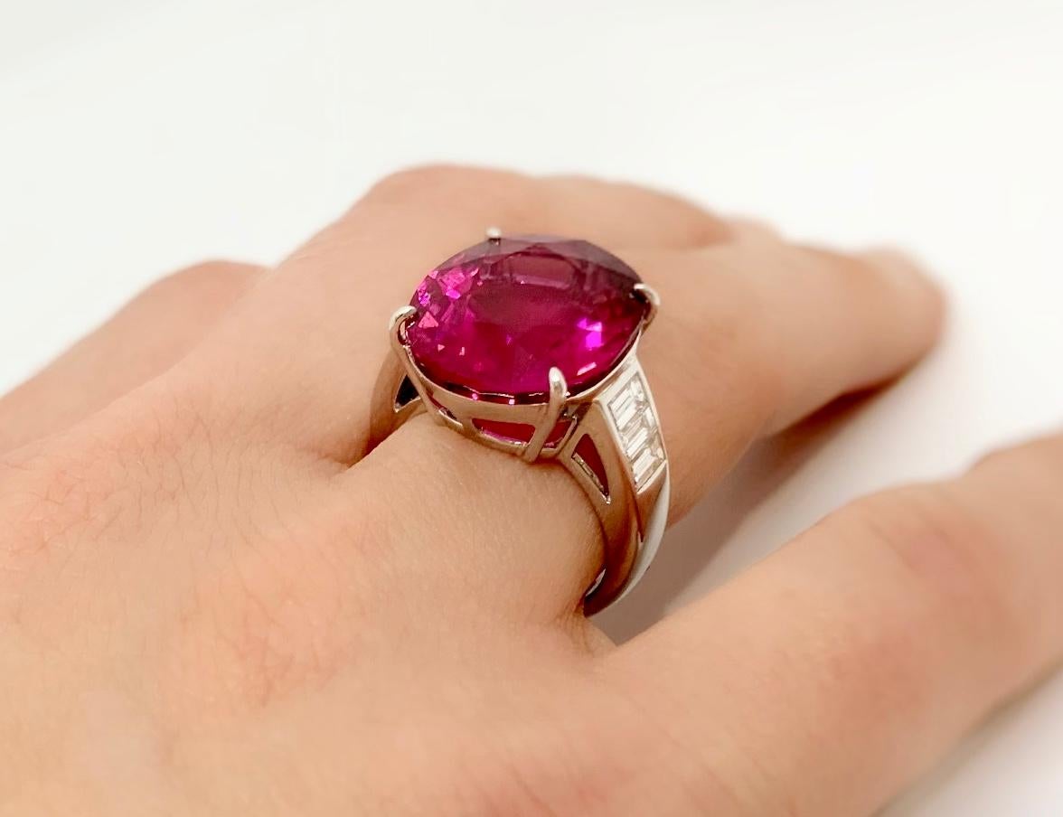 Margot McKinney 18 Karat White Gold Ring with an oval 13.42 carat Rubelite shouldered by a suite of 6 baguette White Diamonds 0.83 carat.  Ring Size US 6 3/4  UK/AU N
