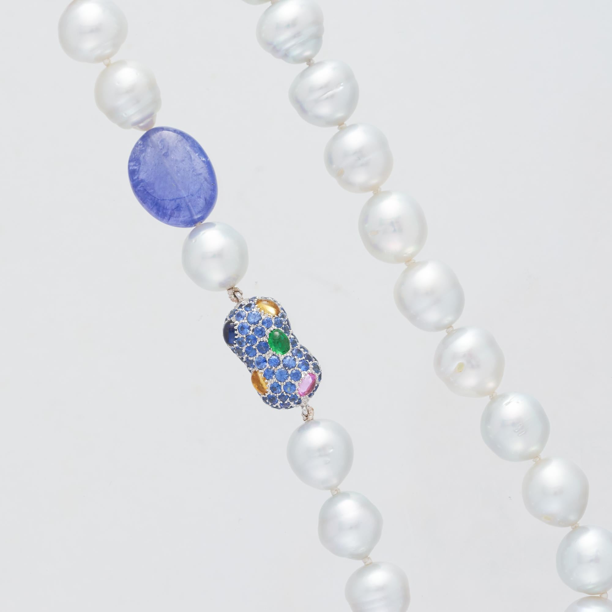 South Sea Pearl and Tanzanite Necklet, 49.50cm long, featuring thirty-nine 10 - 12mm silver white baroque Australian pearls, one Tanzanite bead, one 18 karat white gold diamond and precious stone set 'peanut' enhancer and finished with an 18 karat