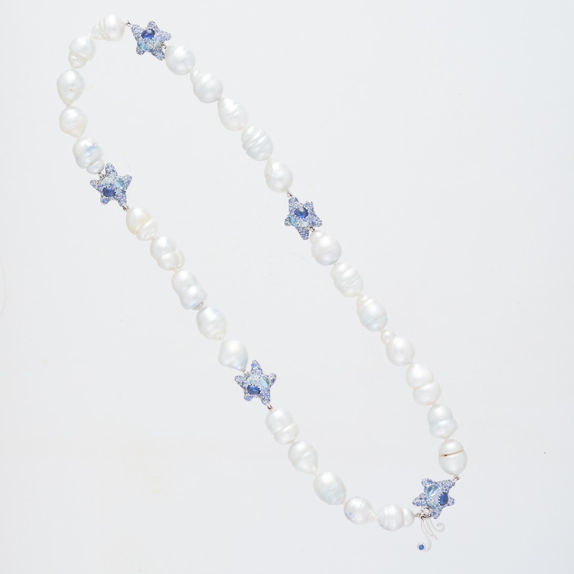 Margot McKinney South Sea Pearl 10-11 mm (27 pearls) Necklet with a suite of Starfish Enhancers set in total with 2 Diamonds 0.04 carat, 528 Sapphires 10.32 carat, 50 Blue Topaz 1.12 carat, 10 oval Sapphires 3.91 carat and 5 oval Blue Topaz in