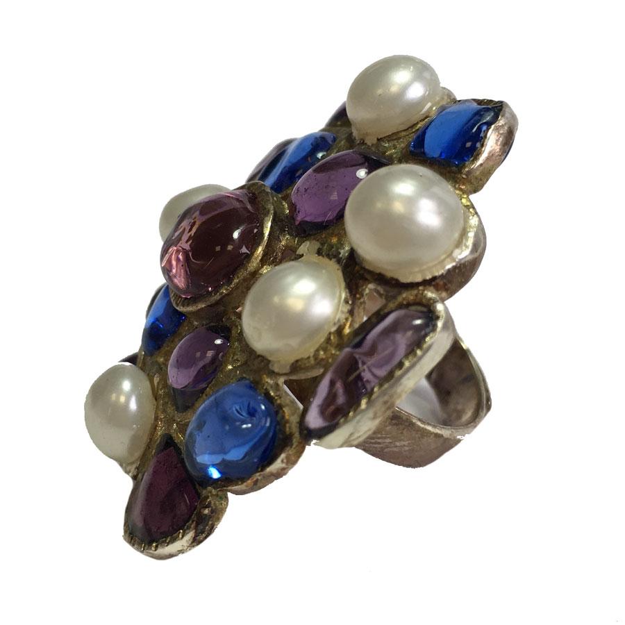 Very beautiful MARGUERITE DE VALOIS round ring in gold metal aged with fine gold, set with mauve and blue stones in molten glass and pearly pearls.
Adjustable ring from size T51 and beyond. Ring made by hand by the artisan jewelers of the Maison