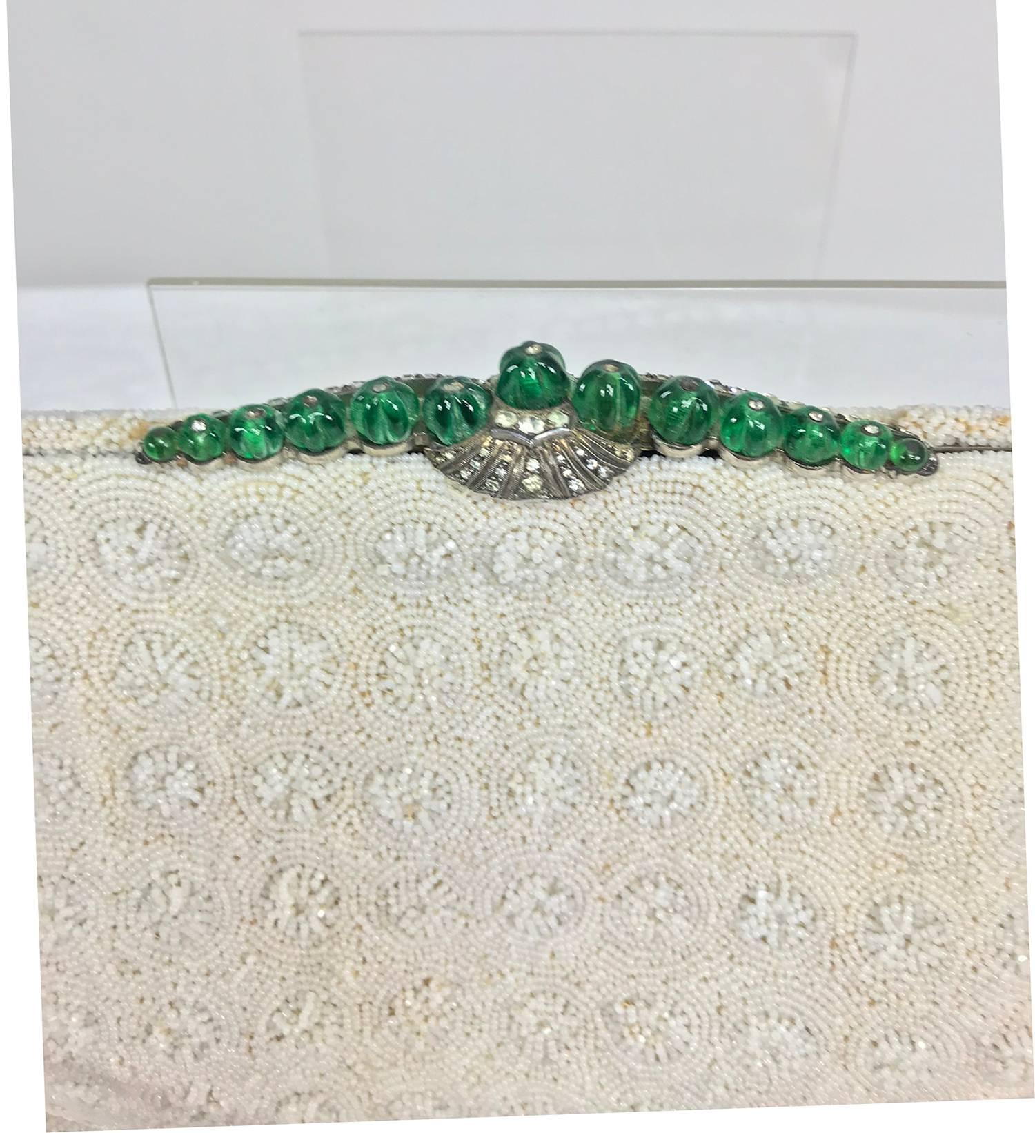 Marguerite Fresse Paris jewel frame white beaded evening bag...Classic 1950s evening bag, the frame is silver metal with a clasp that features rhinestones and round emerald colour carved beads...The bag has circles of snowflakes all done in tiny