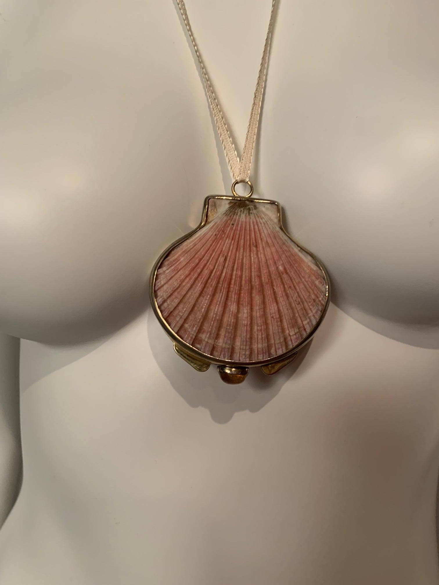This beautiful shell pendant or compact designed by Marguerite Stix in the late 1960's is framed with gilt silver and it has a cabochon orange opal clasp.  The back of the shell is flat so it is comfortable to wear and easy to display.  It is marked