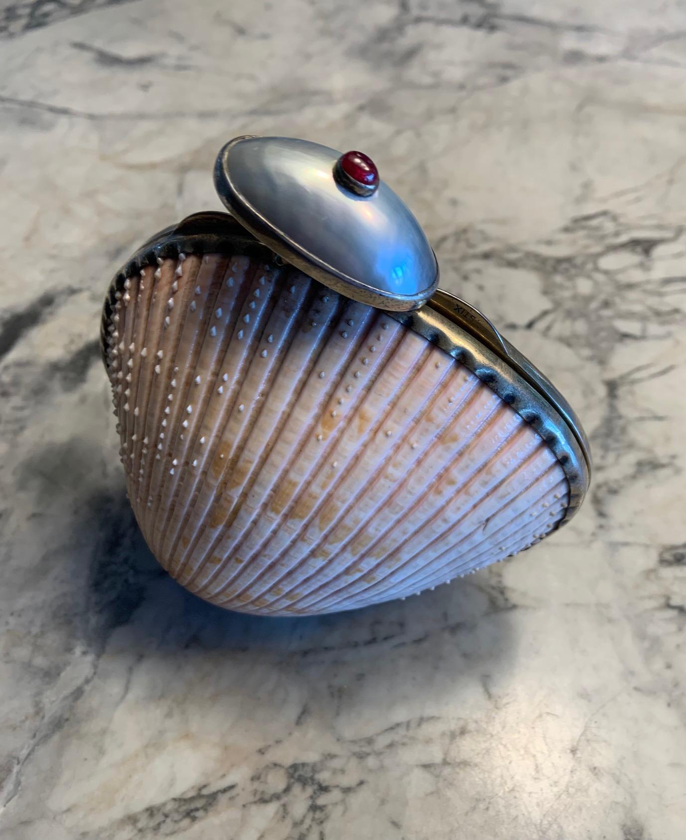 This rare shell minaudiere from Marguerite Stix has a ruby cabochon and large blister pearl for the clasp and a gold washed frame. It is signed Stix on both sides of the clasp and the interior is lined with chamois.  It is in excellent