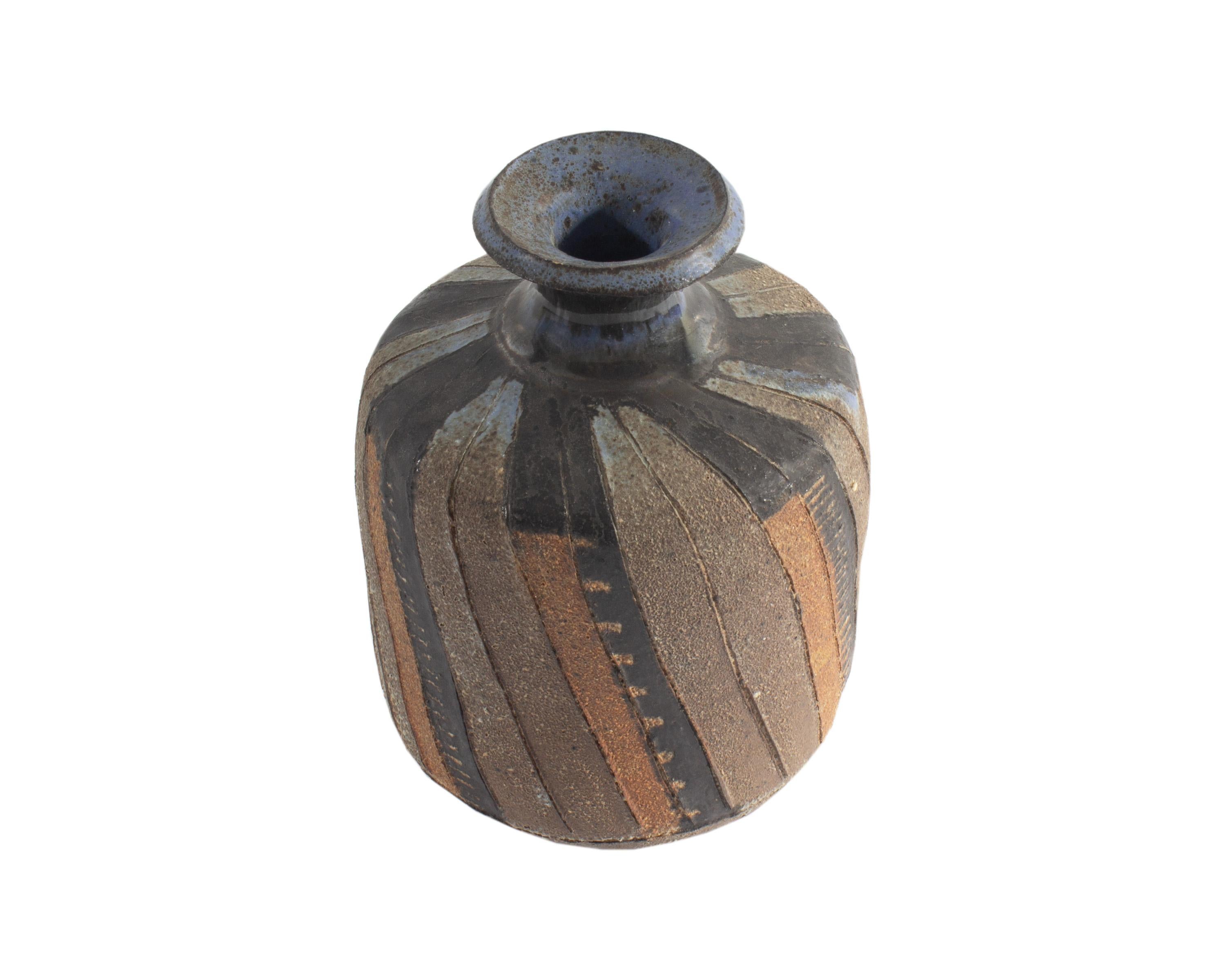 A Pond Farm studio pottery vase by American Bauhaus-trained artist Marguerite Wildenhain (1896-1985). This vessel has vertical stripes, alternating in pairs of unglazed and terracotta and black sections. At the neck and opening of the vase, blue