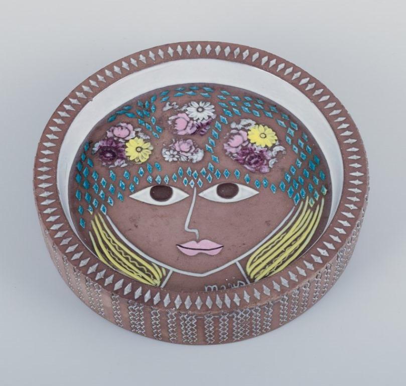 Mari Simmulson (1911-2000) for Upsala Ekeby, Sweden. 
Ceramic bowl in modernist style with a motif of a woman's face.
Approximately from the 1960s.
Model number 5008.
In perfect condition.
Marked.
Dimensions: D 19.0 cm x H 4.0 cm.