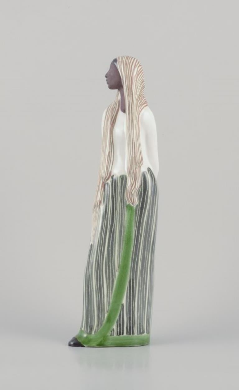 Mari Simmulson (1911-2000) para Upsala Ekeby, Suecia. 
Figurita de cerámica de mujer indonesia.
En perfecto estado.
Firmado.
Dimensiones: Alto 38,0 cm x Ancho 12,0 cm.