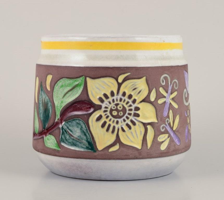 Mari Simmulson (1911-2000) for Upsala Ekeby. 
Ceramic herb pot with polychrome glaze featuring floral motifs.
Approximately from the 1960s.
Marked.
In excellent condition.
Dimensions: Diameter 13.0 cm x Height 11.0 cm.

Mari Simmulson is recognized
