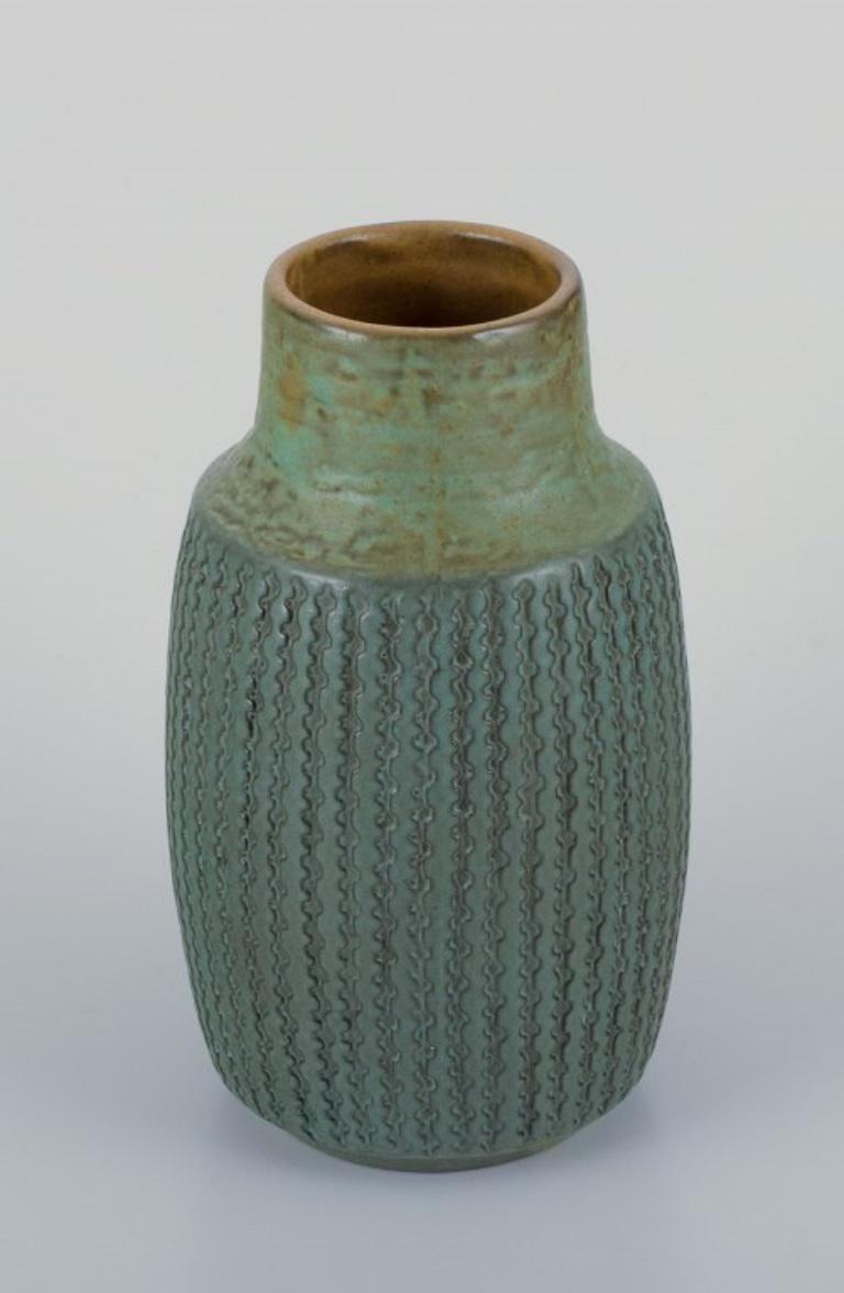Mari Simmulson (1911-2000) for Upsala Ekeby, Sweden. 
Ceramic vase with a geometric pattern in a greenish glaze.
Approximately 1960.
Model number 6080.
In perfect condition.
Marked.
Dimensions: H 20.0 cm x D 11.0 cm.

Mari Simmulson is recognized as