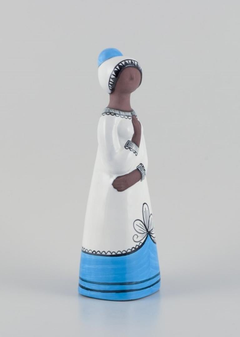 Mari Simmulson (1911-2000) for Upsala Ekeby, Sweden.
Large ceramic figurine of a woman. Hand-decorated.
Model 9033M
Approximately 1960.
Marked.
Perfect condition.
Dimensions: Height 32.0 cm x Width 11.0 cm x Depth 10.0 cm.

Mari Simmulson is