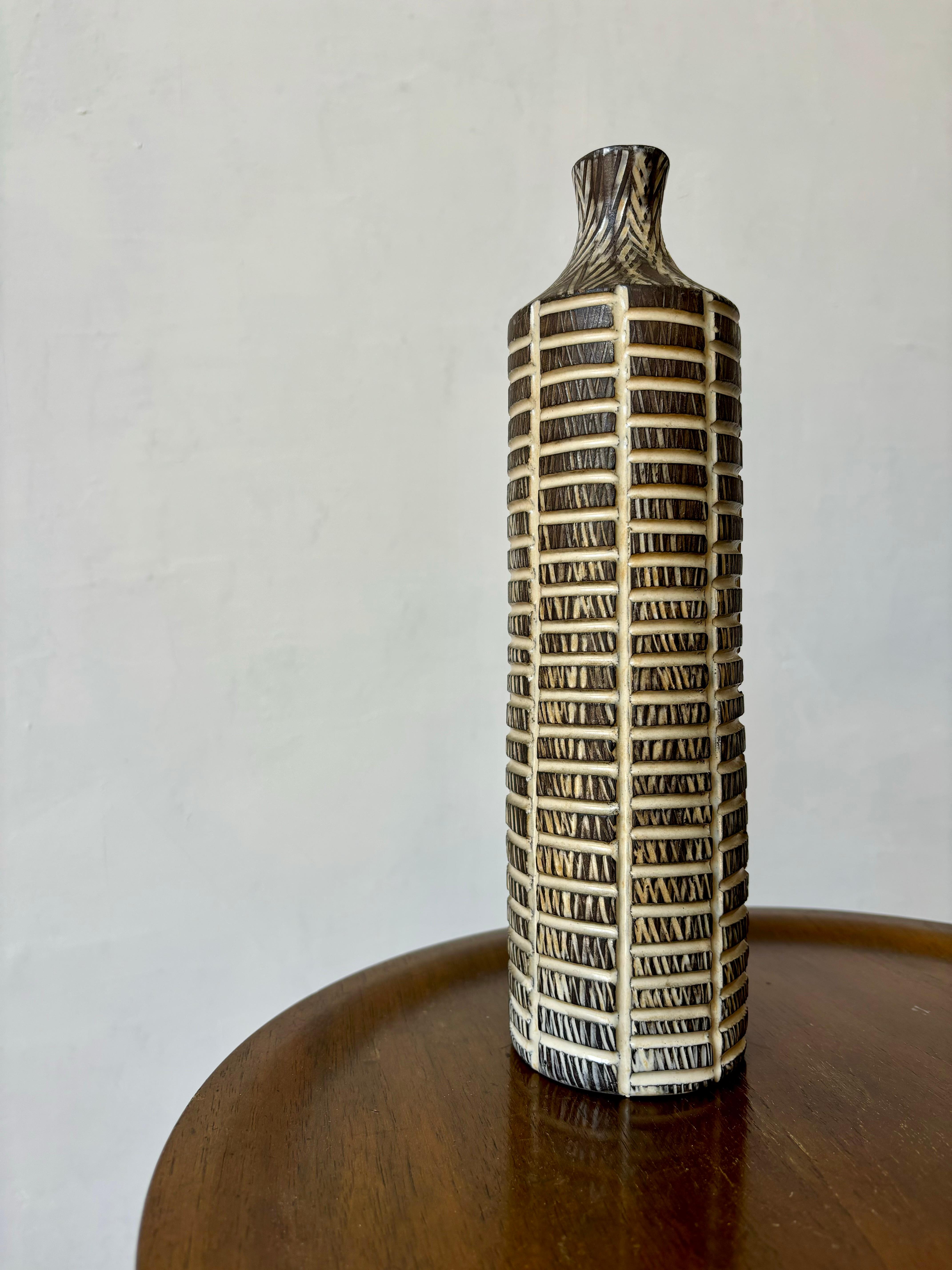 Swedish midcentury modern stoneware vase handmade by artist Mari Simmulson for Upsala Ekeby in 1957. Earthcolored base with hand-carved incised ladder-like graphic decor with cream colored glaze. White glaze on the inside. Large item from the