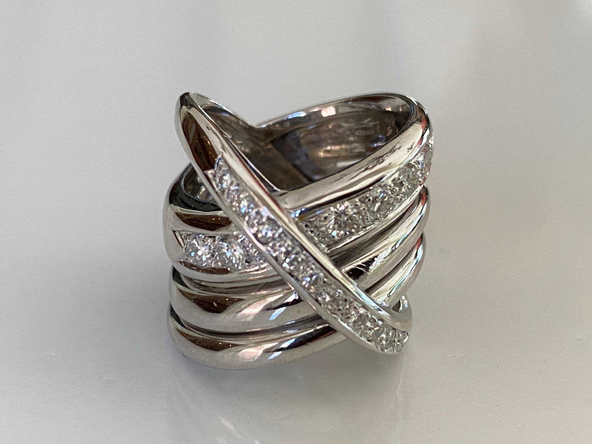 This bold fashion ring crafted in 18kt white gold features a coiled, crisscross design studded with approximately 1.30 carats of fine round diamonds. Signed Maria Grazia Cassetti
