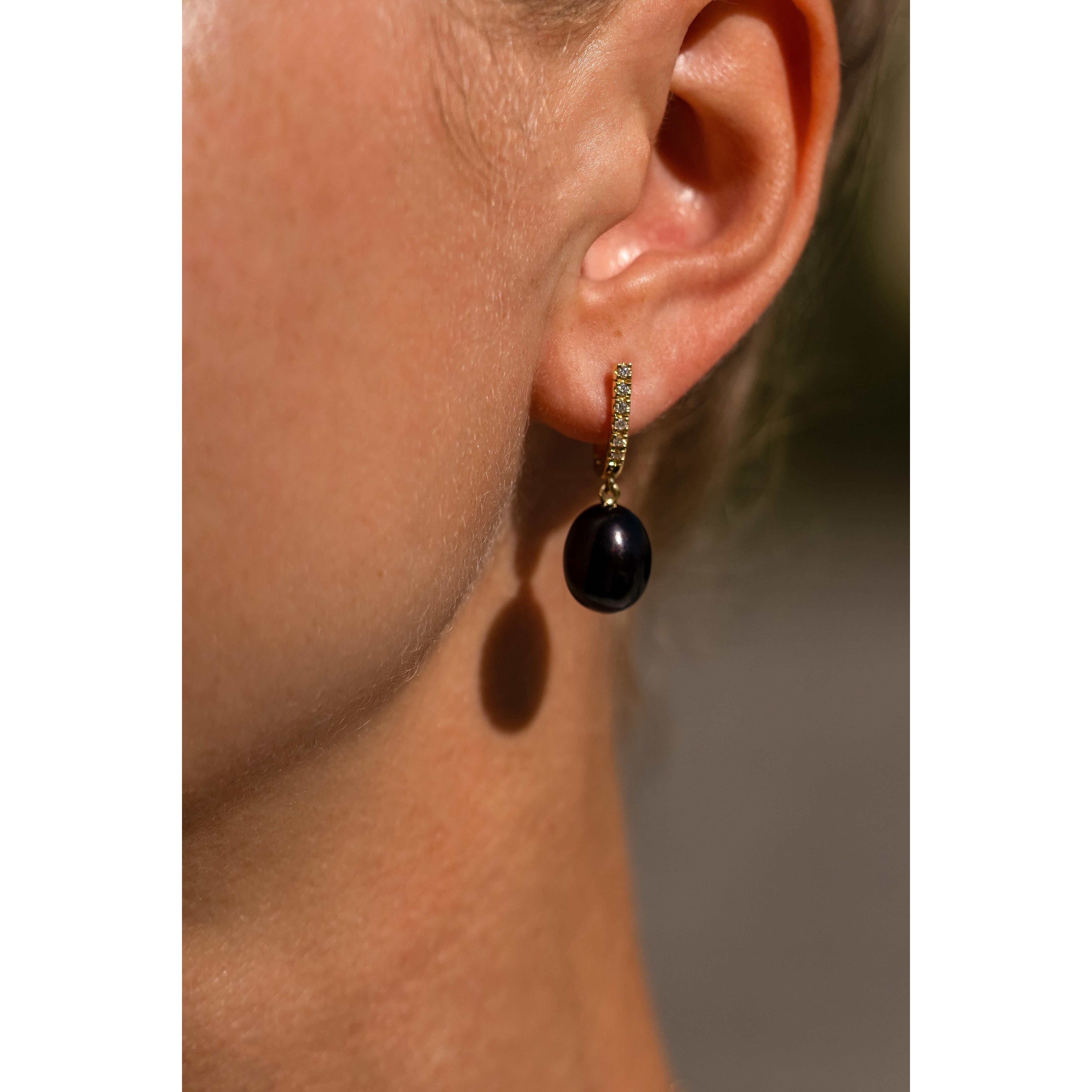 The Black Pearl and Diamond, ear pendants are crafted in 18K yellow gold, hallmarked in Cyprus. These elegant, ear pendants come in a highly polished finish and feature a pair of Black, treated, fresh water Pearls and white Diamonds totaling 0,12