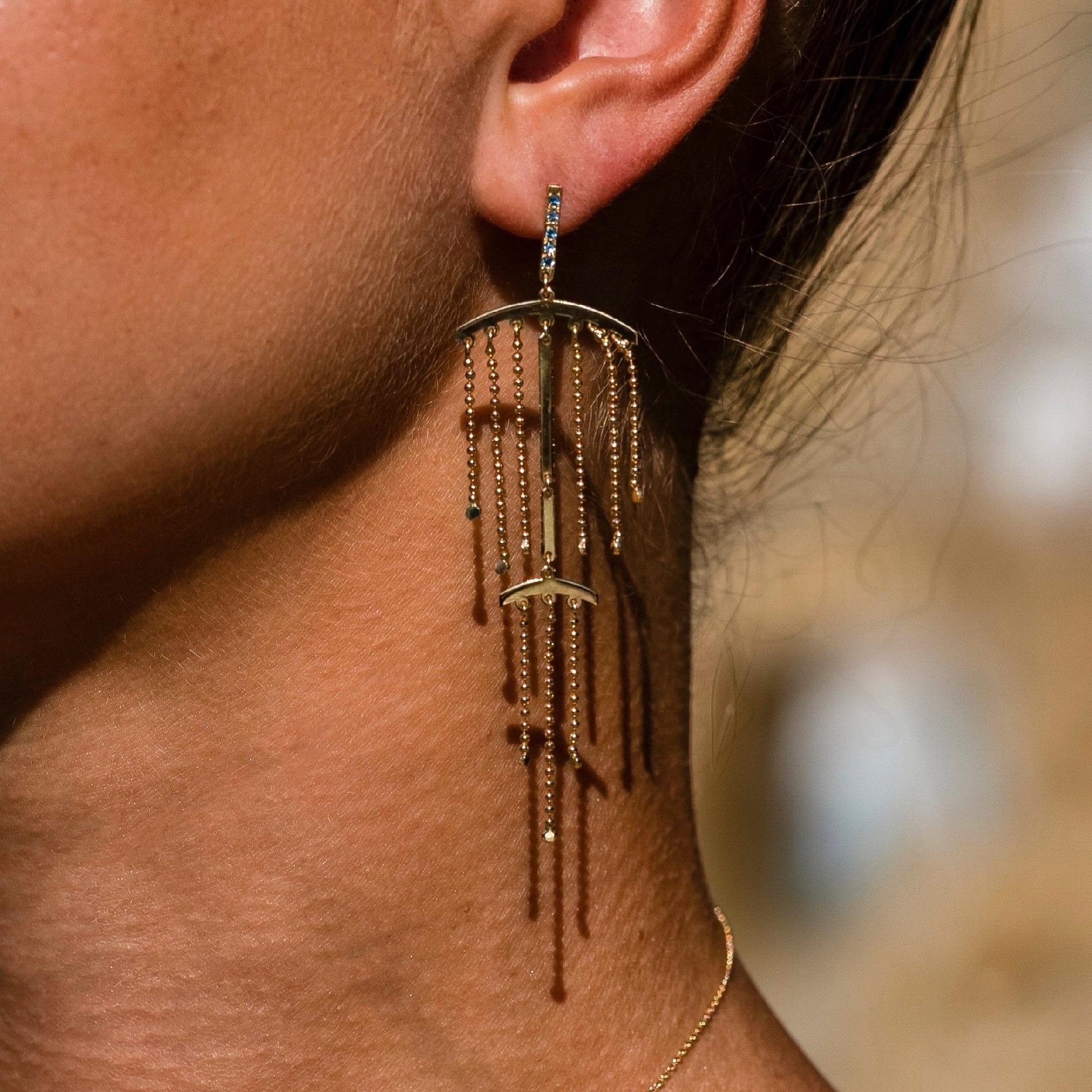 The ‘Double fringe’, chandelier earrings are crafted in 18K yellow gold, hallmarked in Cyprus. These impressive, playful dangle earrings feel light on the ear and are very comfortable to wear. They come in a highly polished finish and feature 0,2