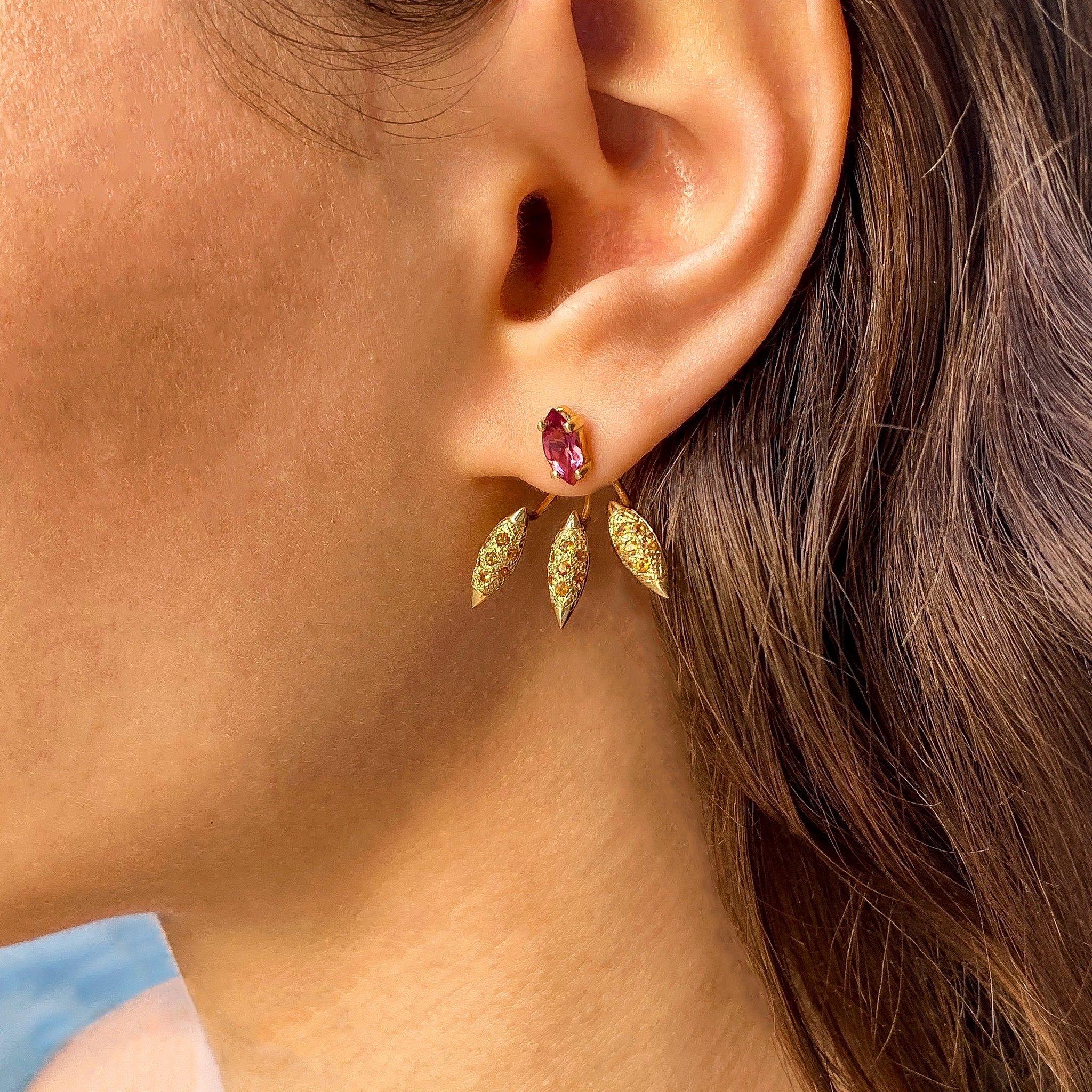 The ‘Grain’, ear jackets are crafted in 18K gold hallmarked in Cyprus. These impressive three part sculptural earrings come in a highly polished finish and feature a pair of marquis cut, Rubellite Garnets totaling 0,8 Cts that can be worn as an