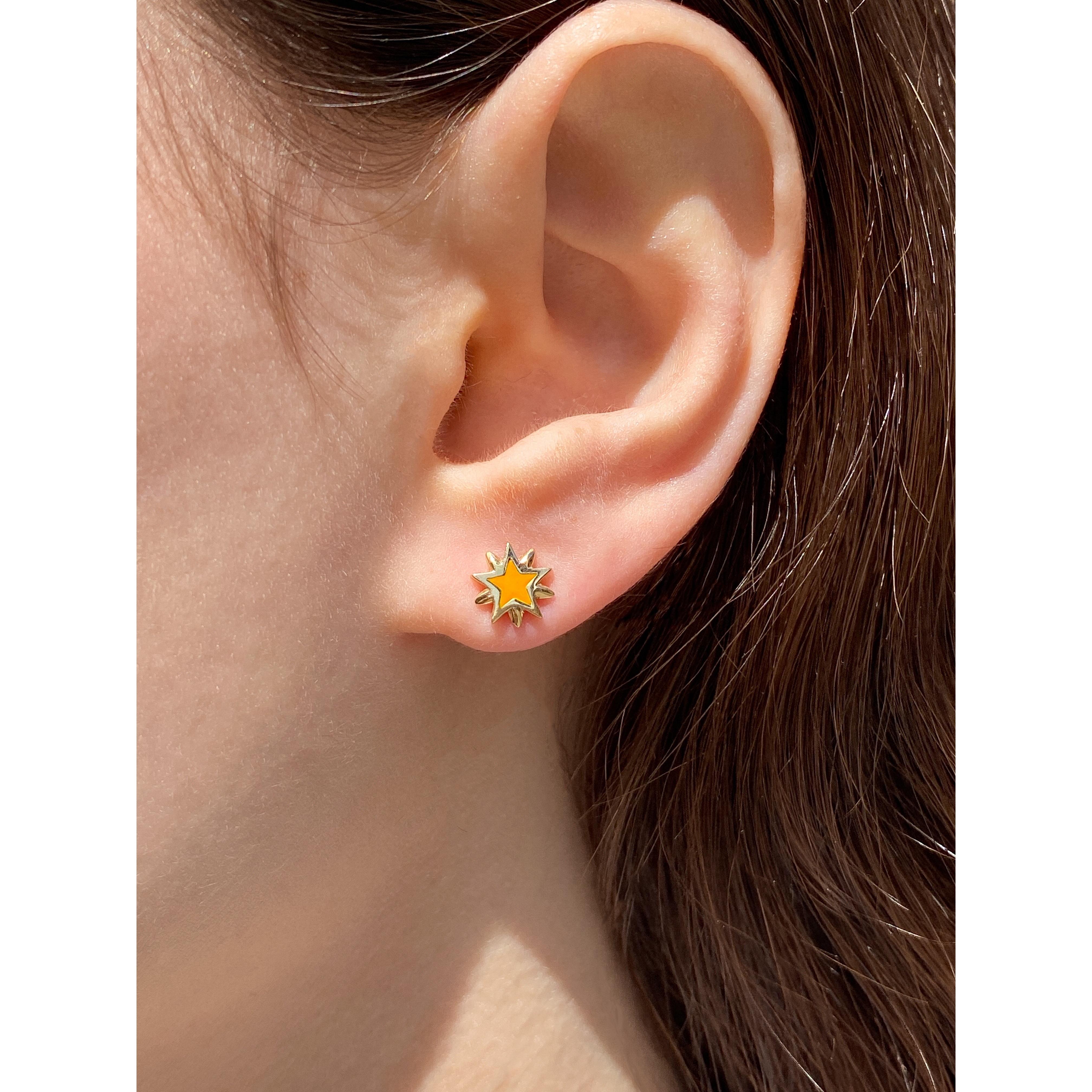The Shiny Star, ear studs are crafted in 18K yellow gold, hallmarked in Cyprus. The cute little star studs come in a highly polished finish and are available in a choice of orange or blue enamel. Whether you wear them alone or layered, they are sure