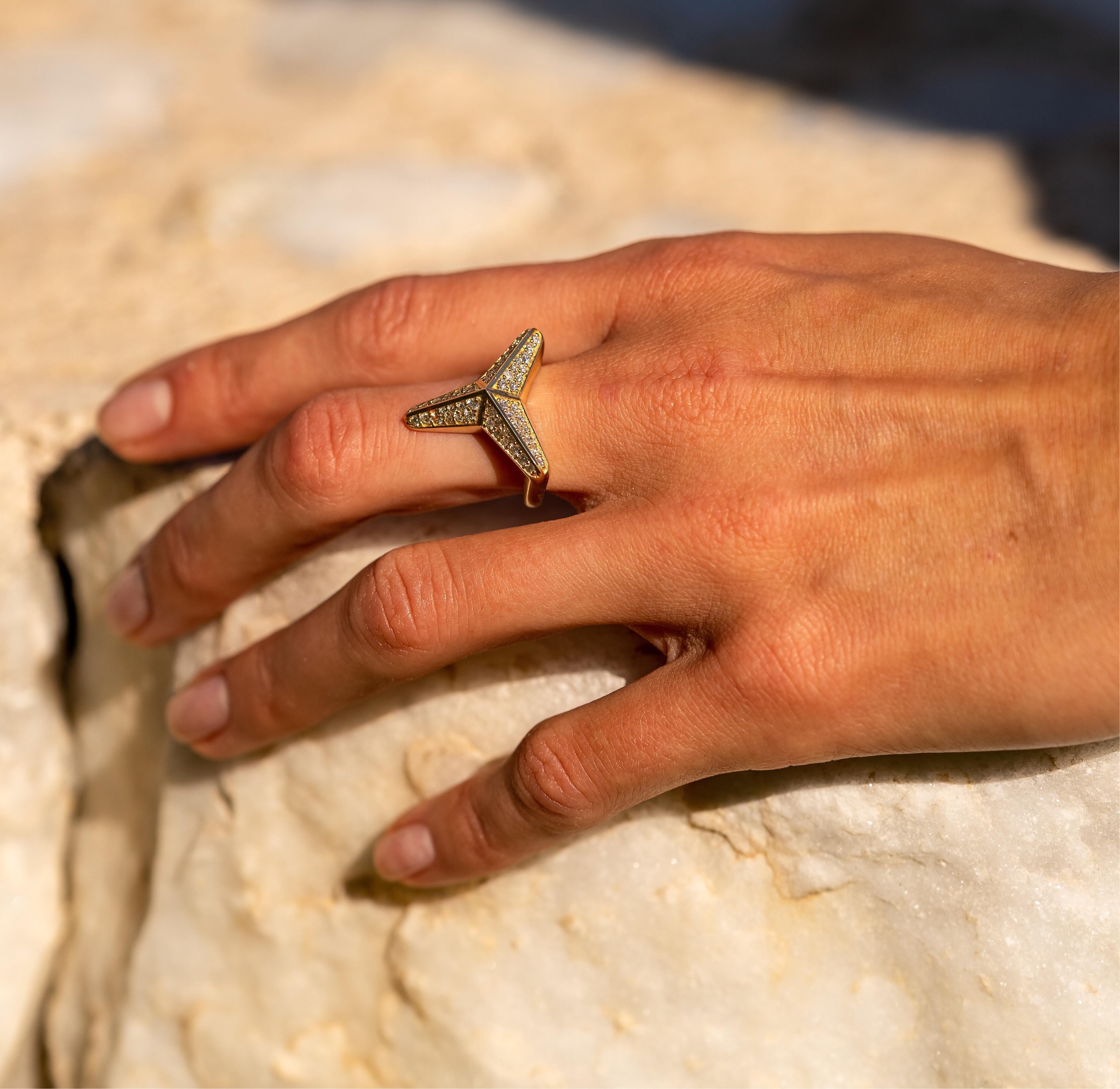 The Three pointed star, diamond ring from Maria Kotsonis' collection features a stunning design crafted in 18K yellow gold, with a hallmark from Cyprus. This statement ring comes in a highly polished finish and is adorned with natural white Diamonds