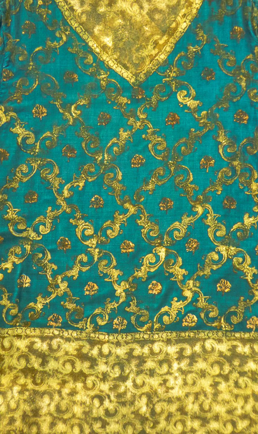 Circa 1928/1930
Italy

Evening jacket with kaftan-cut in peacock blue silk velvet painted and printed with golden motifs inspired by the medieval period from the famous Italian seamstress, Maria Monacci Gallenga, around 1928/1930. Wide and fluid cut