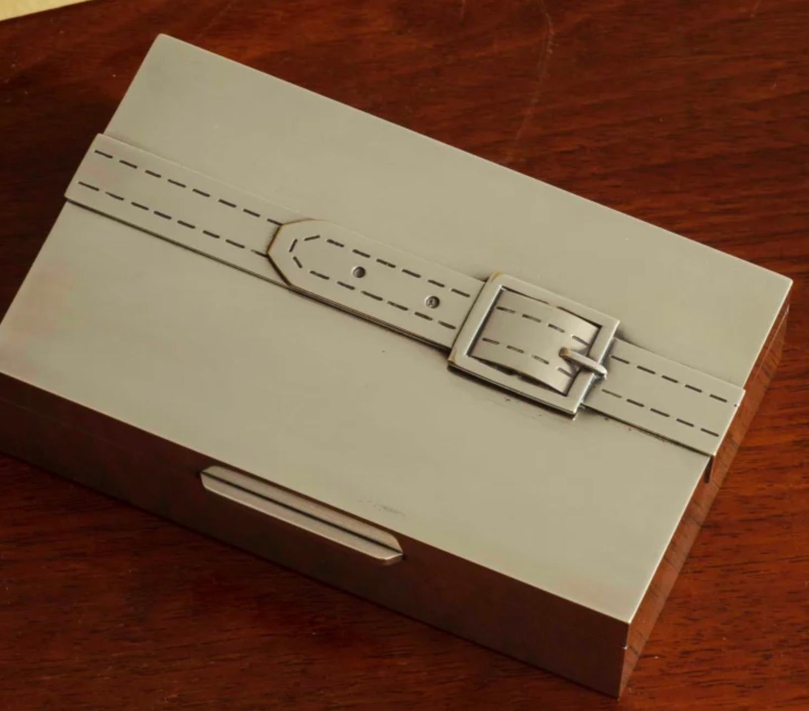 Silver box with cedar lining very plain with engraved belt strap detail.

Typical of the early work of Maria Pergay sold by Hermes.

In original box from Kirby Beard and co.

Paris c. 1950s.
 