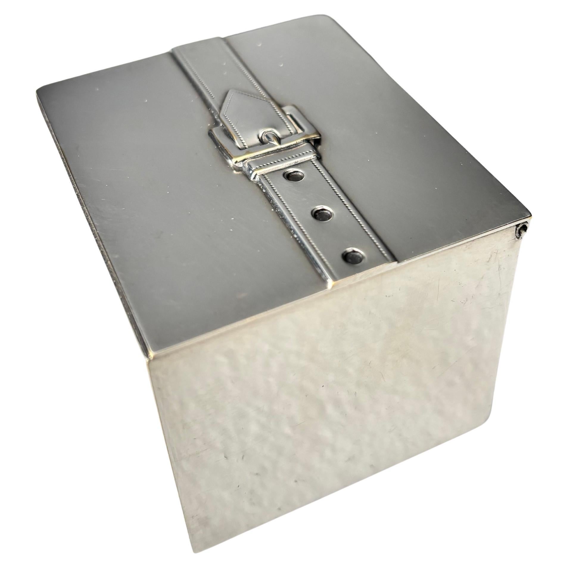 A lovely small jewelry box in silver plate by Maria Pergay. 
The box features the iconic belt and belt buckle seen in many of her decorative objects and boxes of various sizes. The interior held some kind of precious object. Stamped with the number