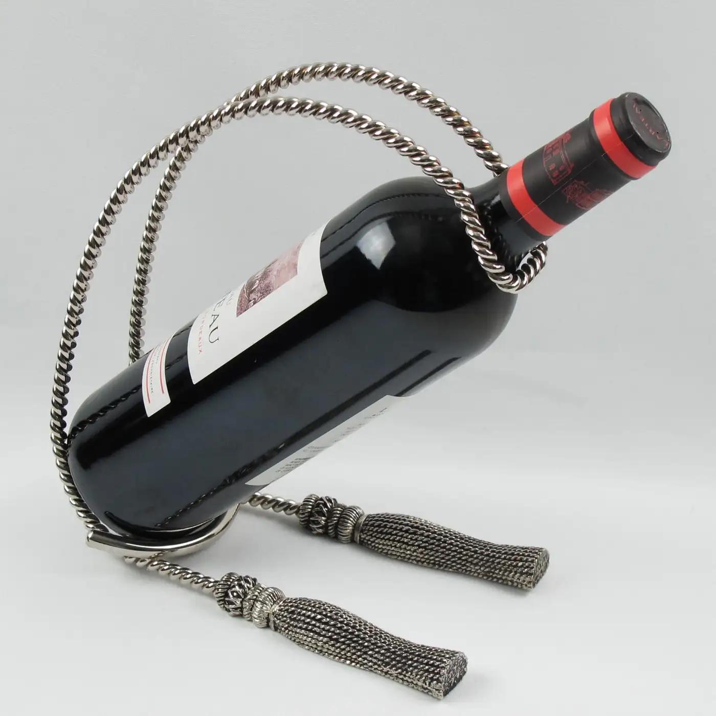 This lovely French wine bottle holder, pourer, or caddy in silver plate metal has an elegant shape with two large tassels base and rope carving. The classic and refined constructed design is reminiscent of Maria Pergay's work. There is no visible