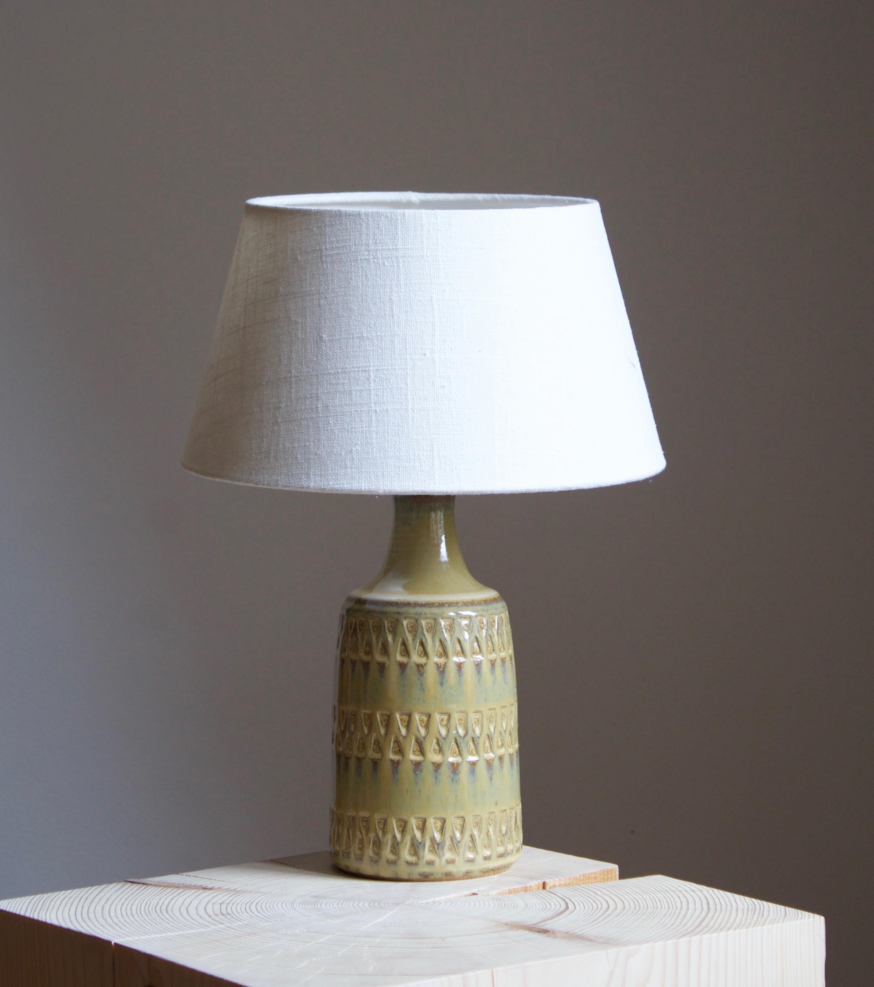A table lamp produced by Søholm Keramik, located on the island of Bornholm in Denmark. Features a highly artistic glazed and incised decor. 

Sold without lampshade. Stated dimensions exclude the lampshade.

Glaze features a green color.

Other