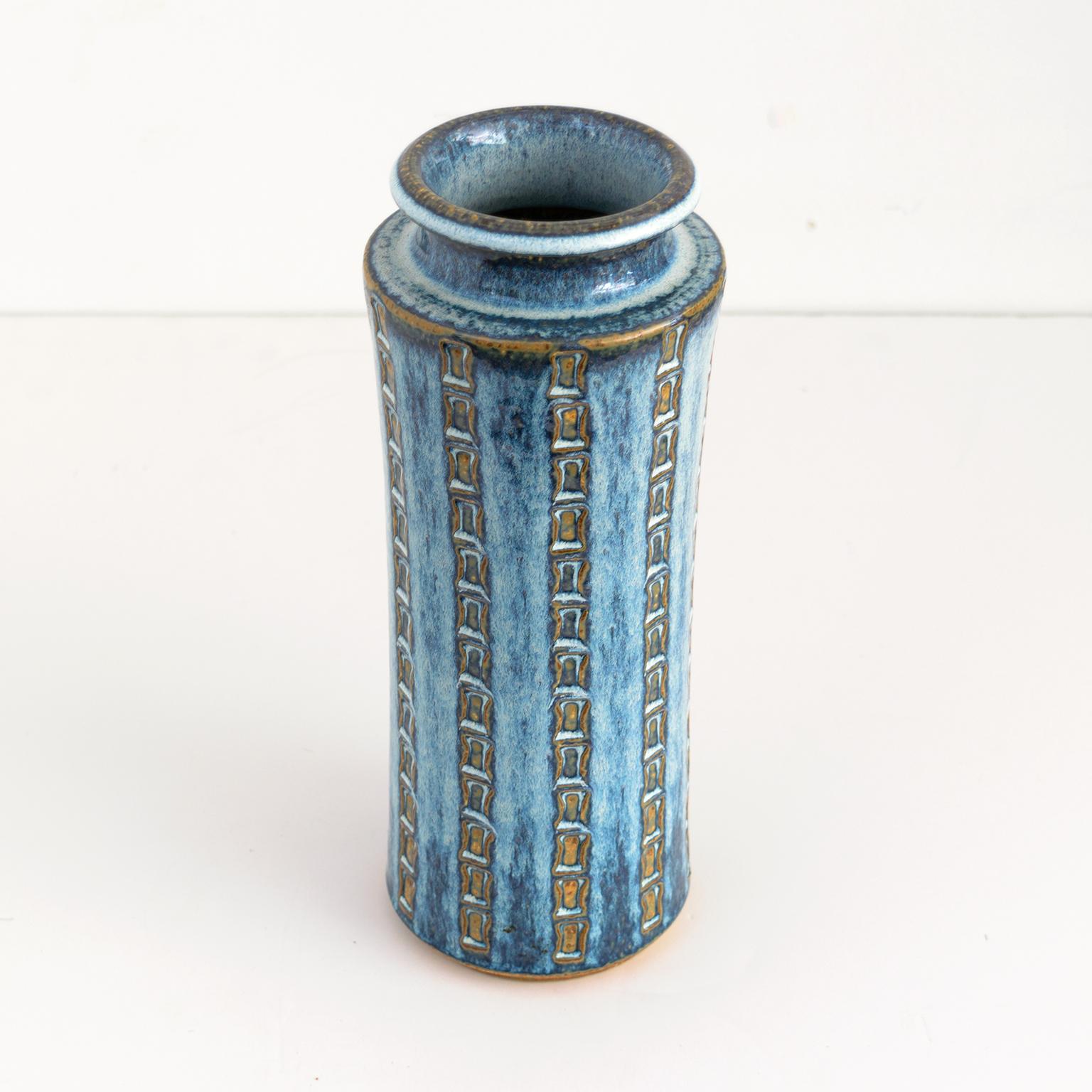 Maria Philippi tall vase with impressed patterns with pale blue glaze over deep blue and brown glazes. Made at Soholm, Denmark. 

Measures: Height: 11.5”. Diameter: 4.5”.