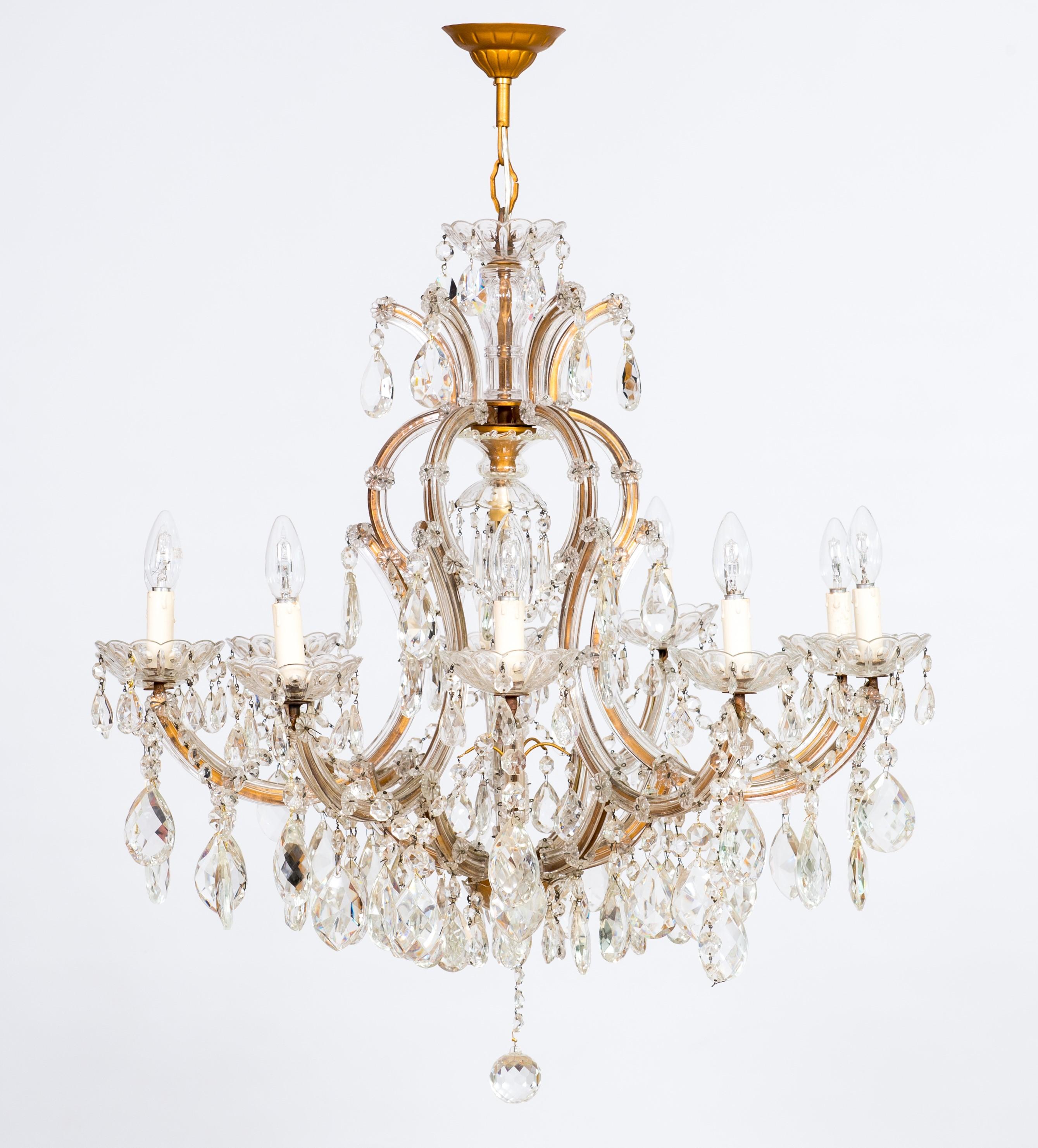 Maria Theresa chandelier in transparent Murano glass, Italy, 1930s.
This chandelier is simply astonishing. The framework is in golden iron, surrounded by transparent Murano glass. There are 11 lights and a profusion of crystal decorations,