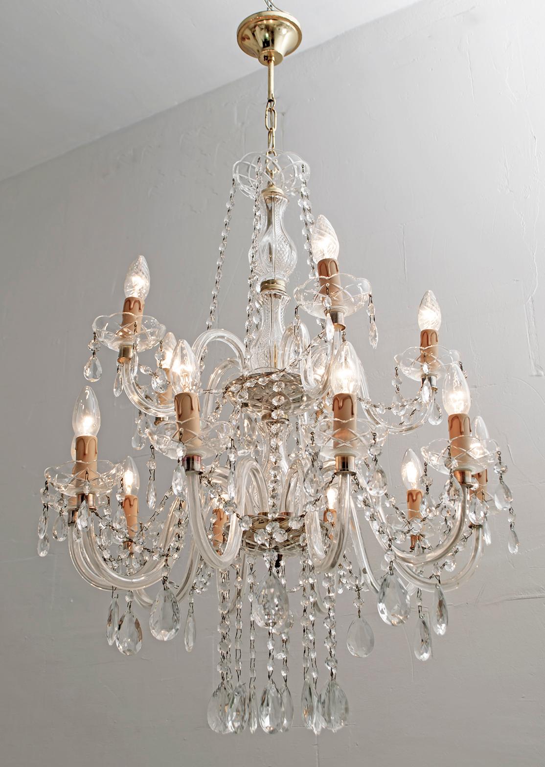 A delightful 15-light Maria Theresa chandelier in Italian crystal and gilded metal with serpentine arms, each candle light with hanging pendants and decorative bobeches.