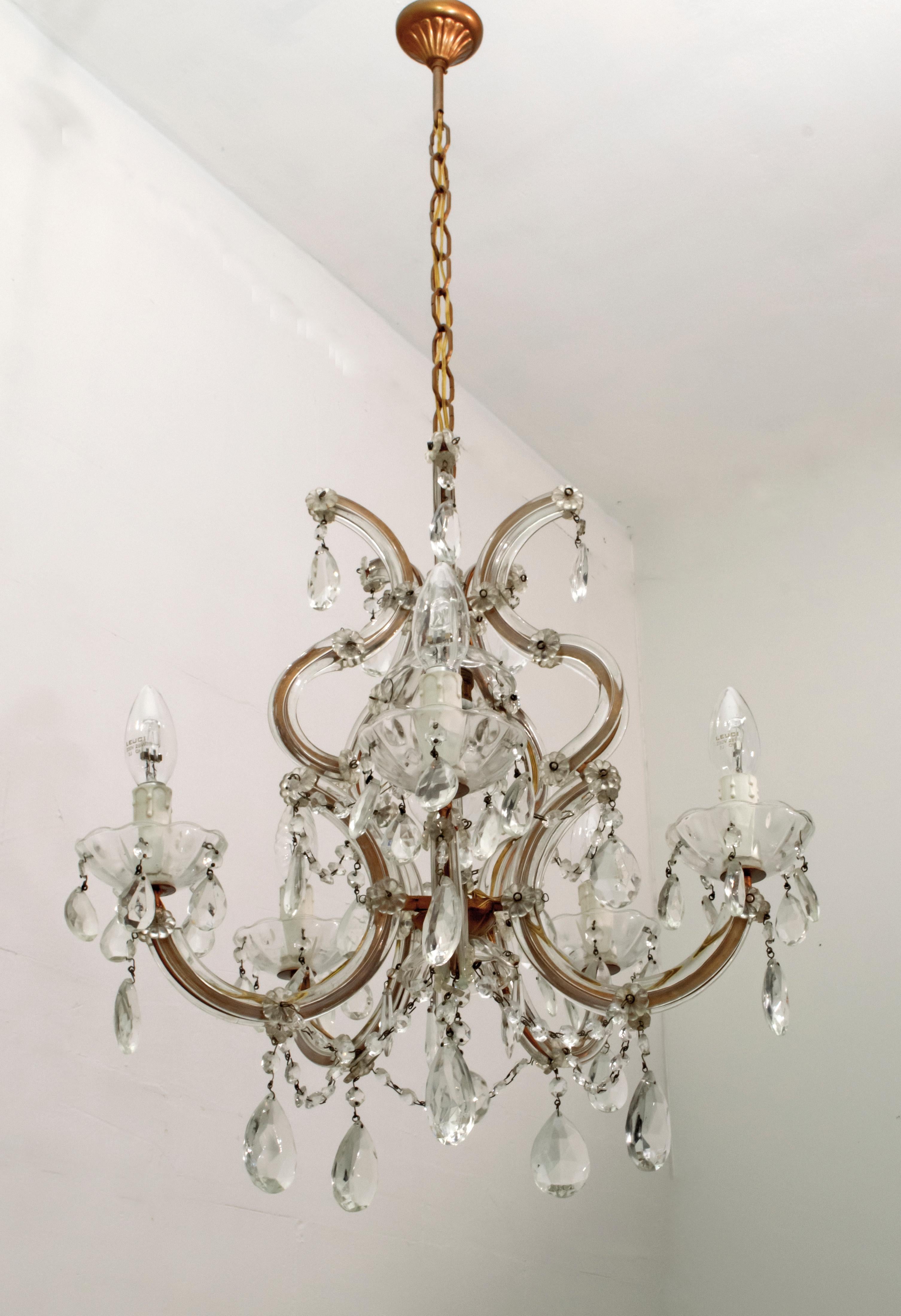 A delightful 6-light Maria Theresa chandelier in Italian crystal and gilded metal with serpentine arms, each candle light with hanging pendants and decorative bobeches.

