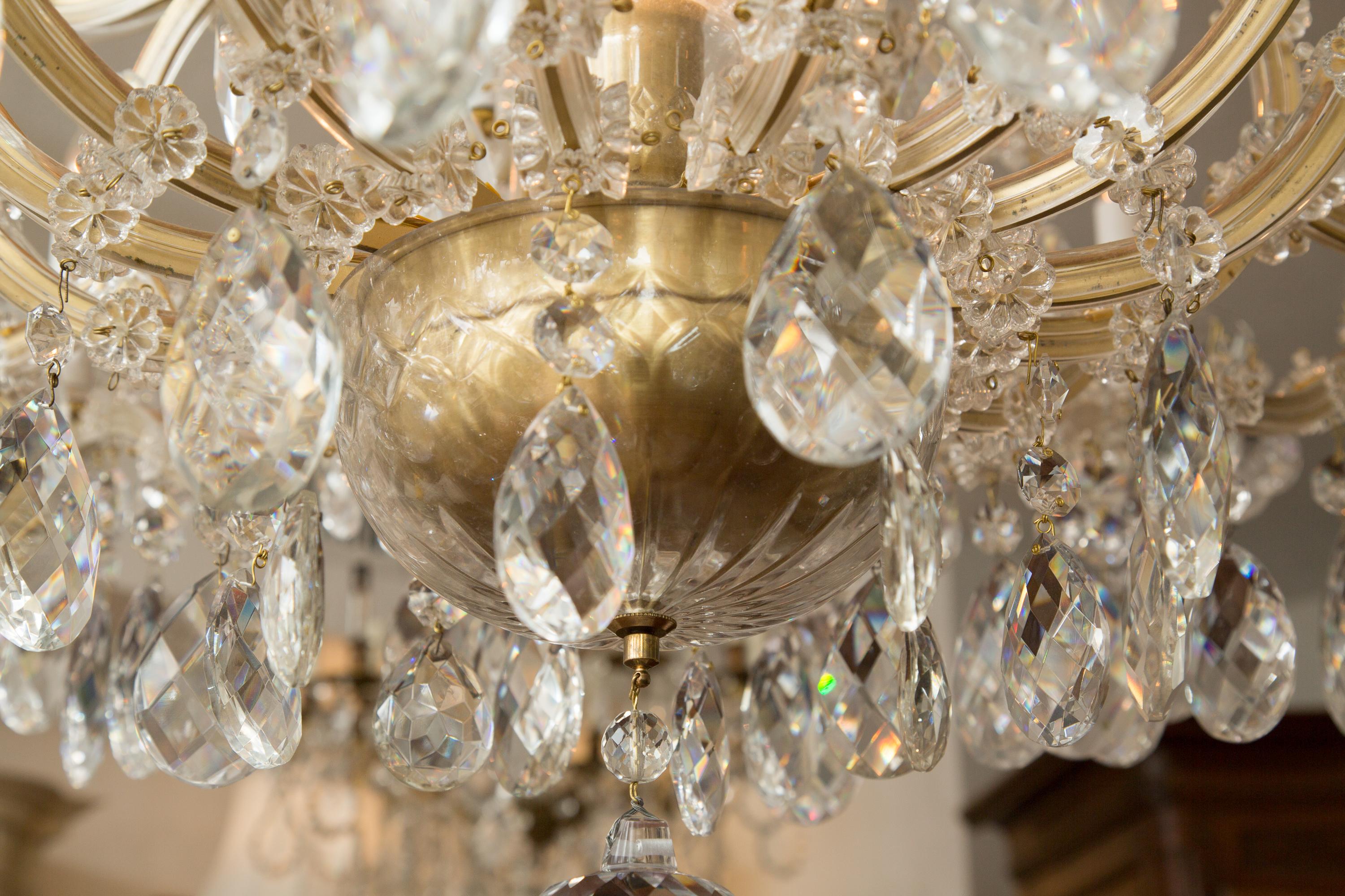 This is a sumptuous hanging chandelier with many curves and shimmering crystal pendalogues. When lighted the chandelier is illuminated the aura is majestic and regal. This is a fine and sophisticated light piece that provides radiance and atmosphere