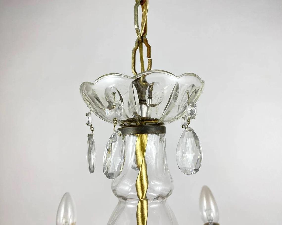 Lustre vintage de style Marie-Thérèse avec six bras en laiton sur lesquels sont installées de fausses bougies.

Allemagne.

Le cadre est en laiton doré, entouré de cristaux 100 % transparents qui capturent et reflètent la lumière des ampoules