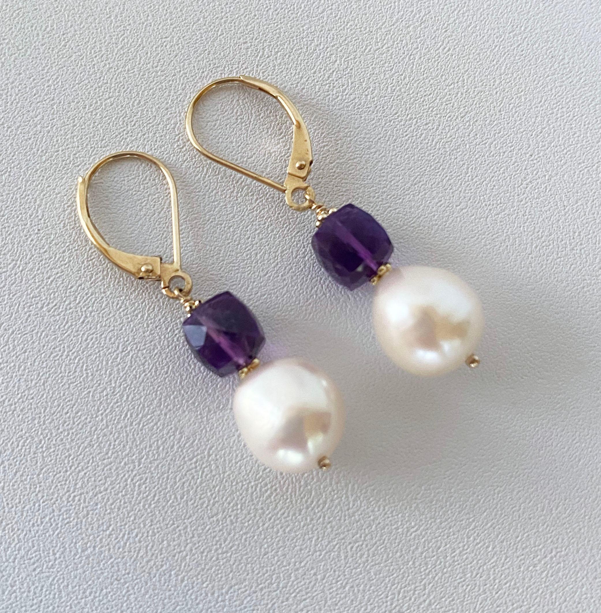 Gorgeous and simple pair of earrings made by Marina J. In Los Angeles. This pair features two gorgeous faceted square Amethysts from which slightly Baroque White/Cream Pearls hang. The Amethyst's translucency allows it to illuminate and radiate