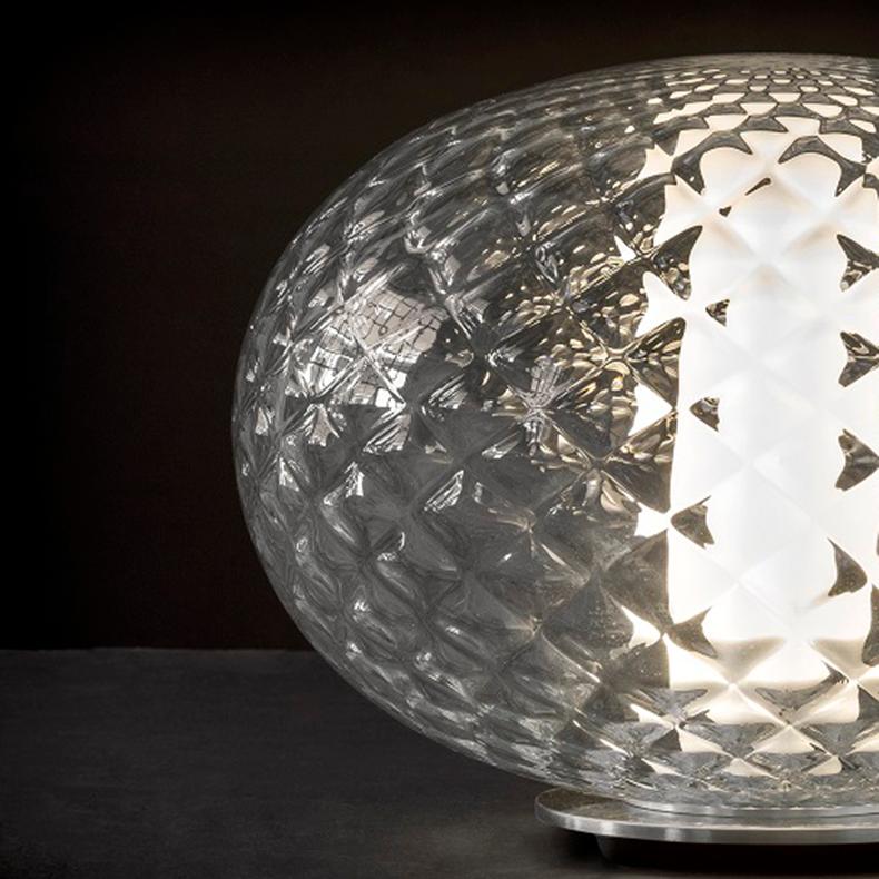 Lampe de table 'Recuerdo' conçue par Mariana Pellegrino Soto en 2017.
Lampe de table diffusant une lumière led dans un verre soufflé transparent et texturé. Lumière de couverture en PMMA transparent satiné.
Fabriqué par Oluce, Italie.

Recuerdo,