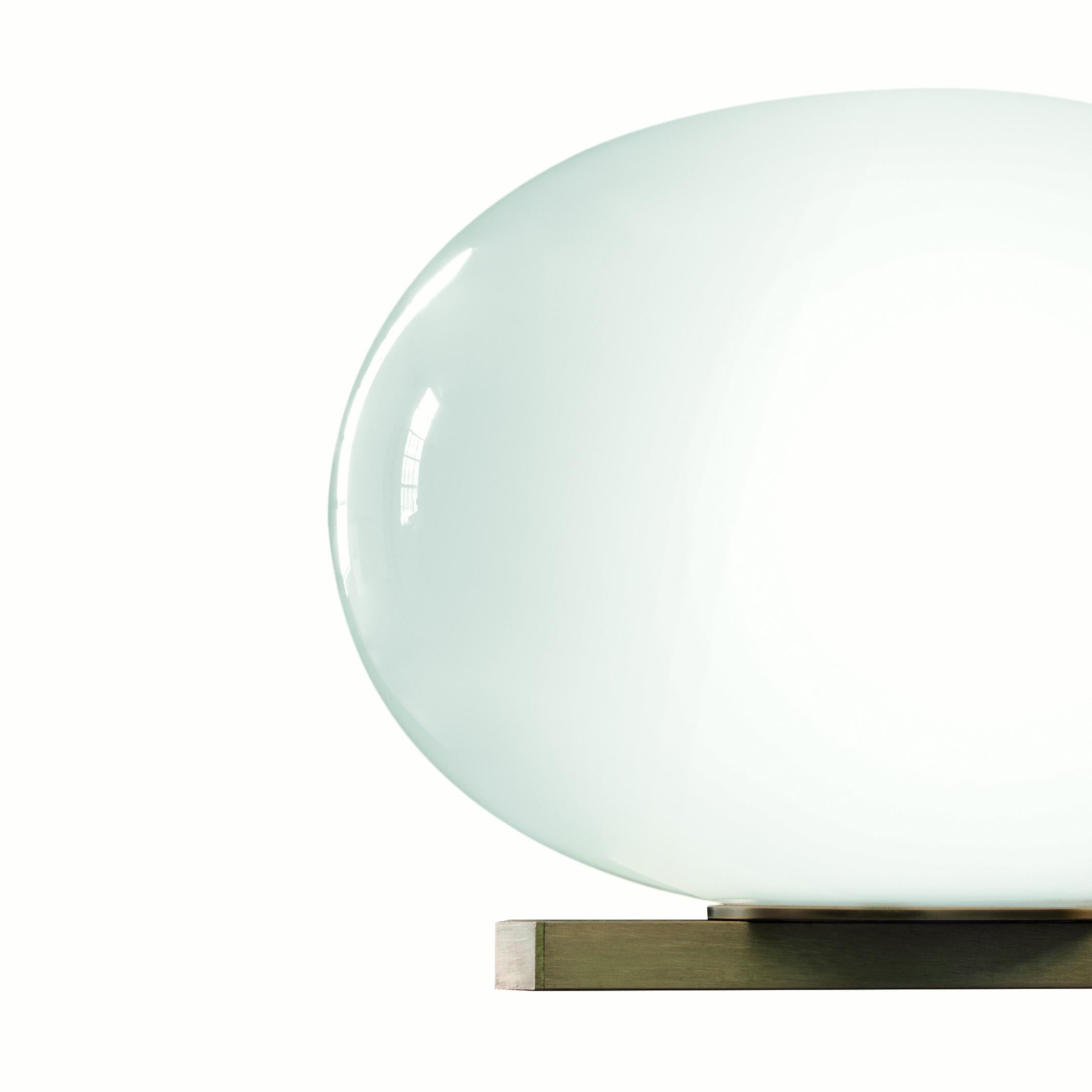 Wall lamp 'Alba' designed by Mariana Pellegrino Soto in 2019.
Wall lamp giving diffused light in polished opaline blown-glass. Satin brass finish structure with rectangular profile. Manufactured by Oluce, Italy.

The concept of Alba starts with a