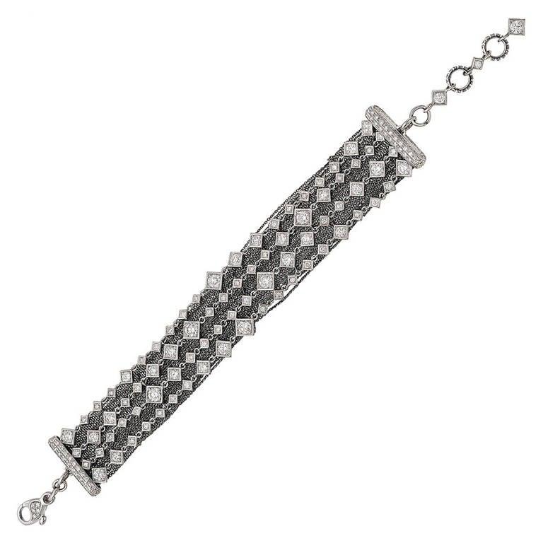 4-strand diamond-set chain bracelet in 18k white gold, with round diamonds set in square-shaped motifs, highlighted by a contrasting 18k blackened white gold multi-chain back section, with pavé diamond terminals and diamond-set links at either end,