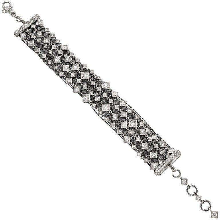 4-strand diamond-set chain bracelet in 18k white gold, with round diamonds set in square-shaped motifs, highlighted by a contrasting 18k blackened white gold multi-chain back section, with pavé diamond terminals and diamond-set links at either end,