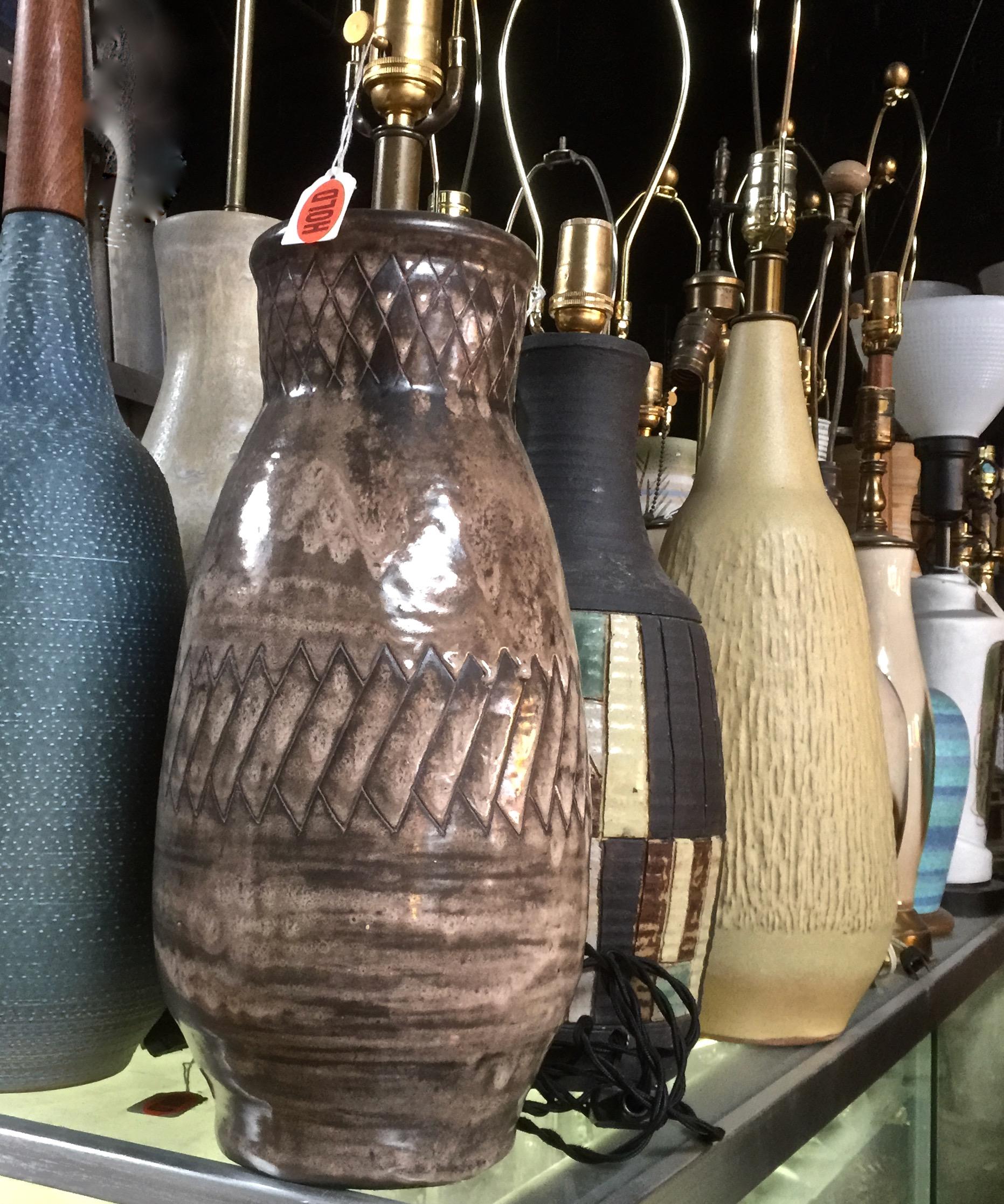 Marianna von Allesch handcrafted Earthen Glazed Ceramic Table Lamp. Featuring a hand thrown, natural bottle form, hand washed, reflective, hand incised diamond geometric pattern, with mottled Taupe, Sand, Coffee coloration and Brass stem. Glossy.