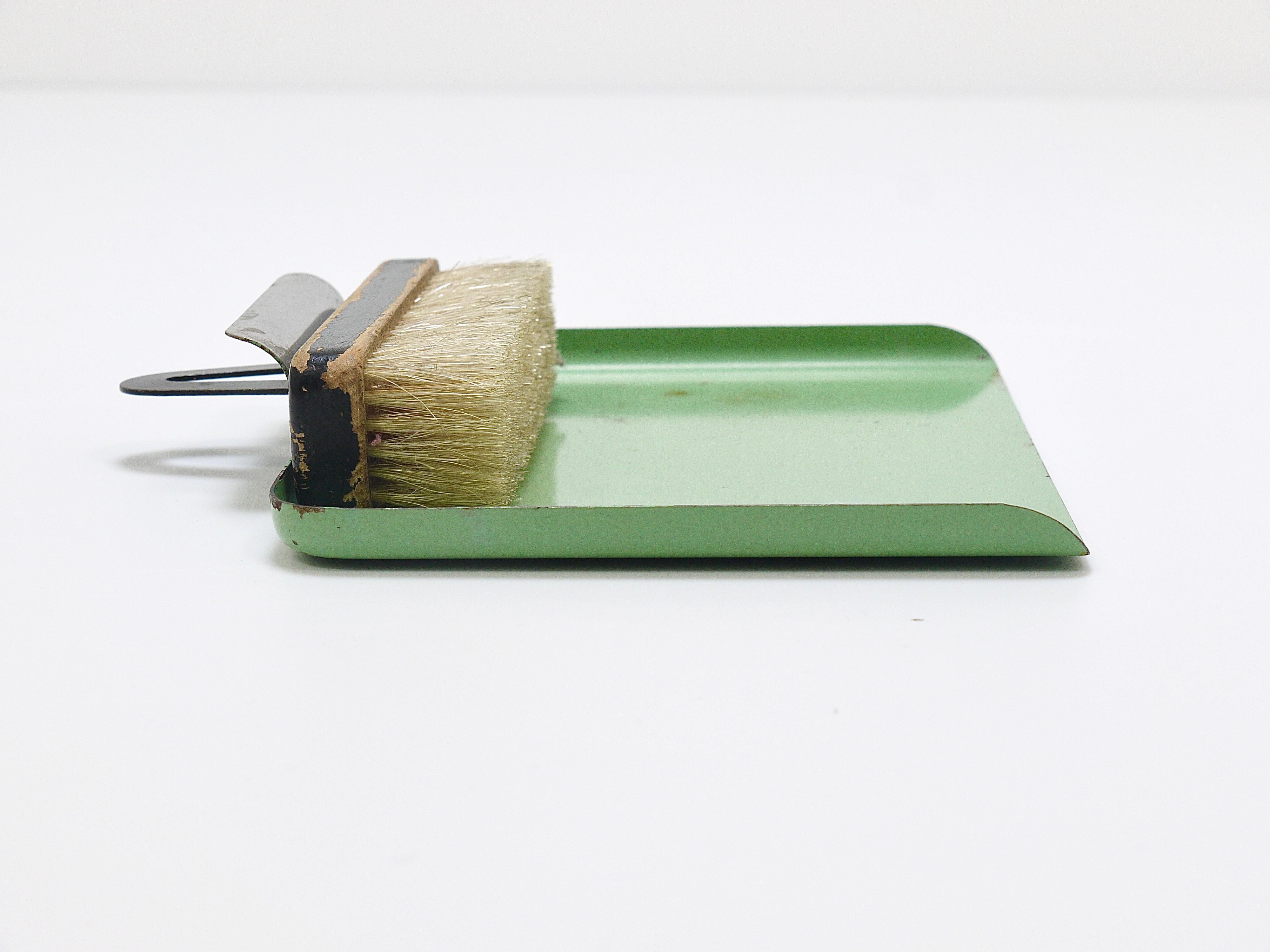 An iconic Bauhaus table brush and pan sweeping set from the early 1930s in light-green / pastel jade green. Designed by Marianne Brandt (1893-1983), manufactured by Ruppel Werke, Ruppelwerke in Gotha, Germany. Made of sheet metal and wood. In good